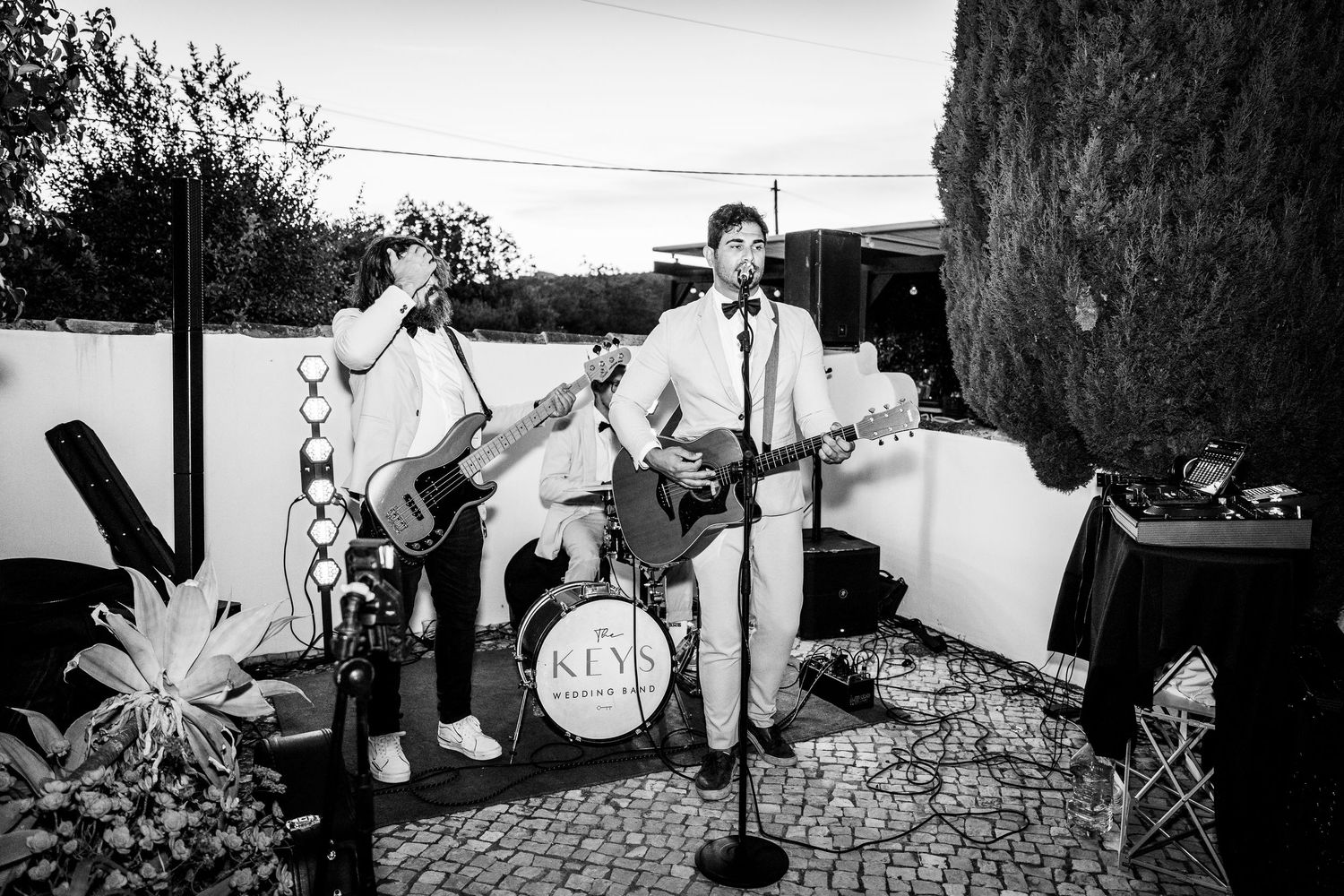 Black and white sequence showing people gathered around a table with pineapples in an outdoor setting.