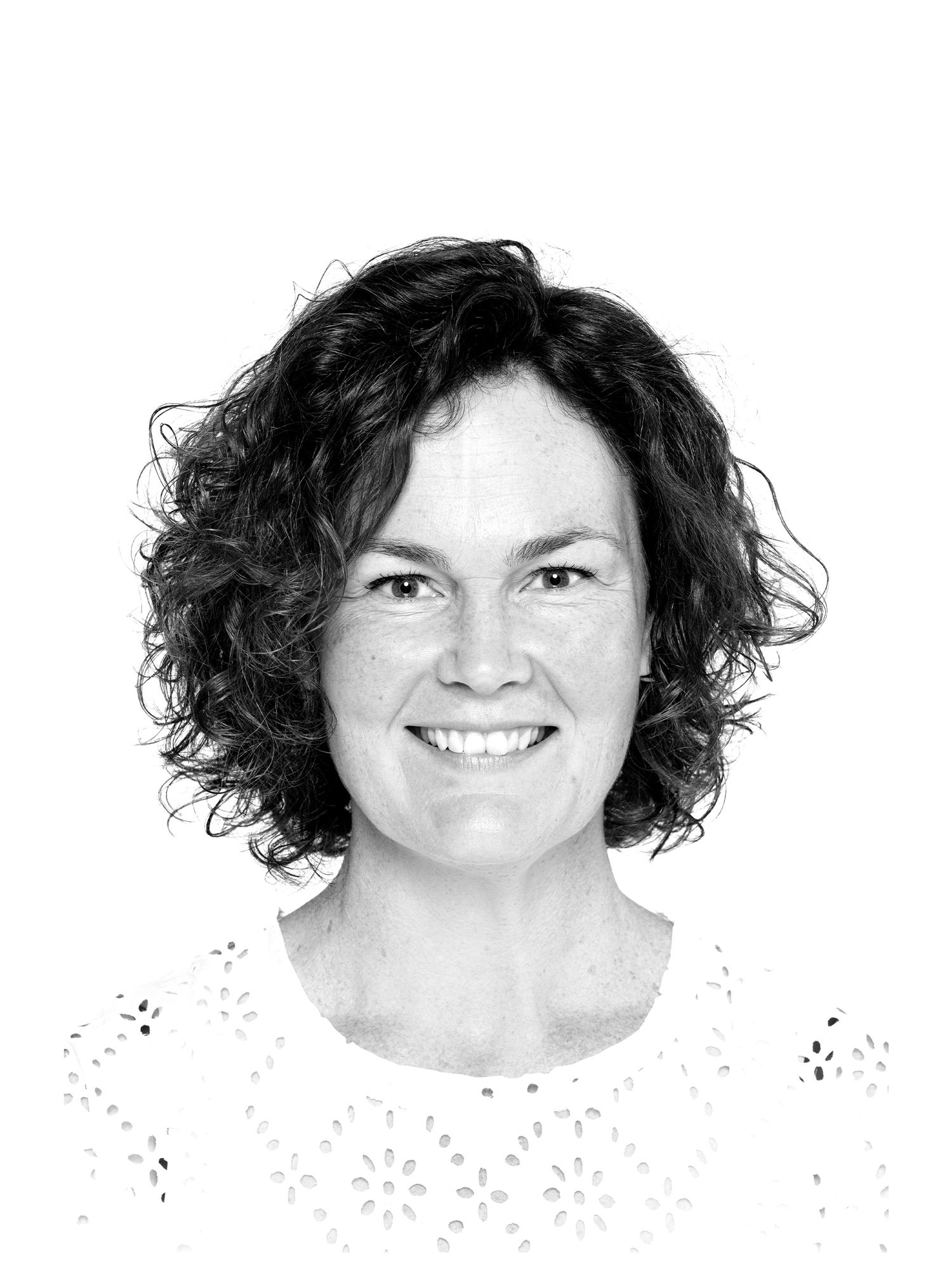 Four black and white headshots showing a person with curly dark hair and a warm smile against a white background.