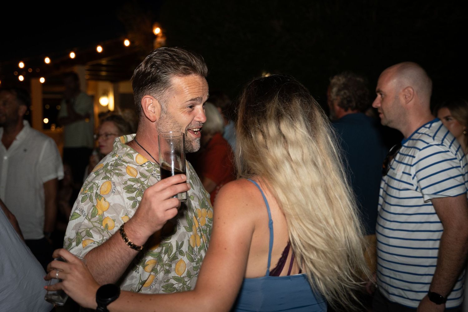 A panoramic series of candid socializing moments at a dimly lit party or gathering with people interacting and laughing.