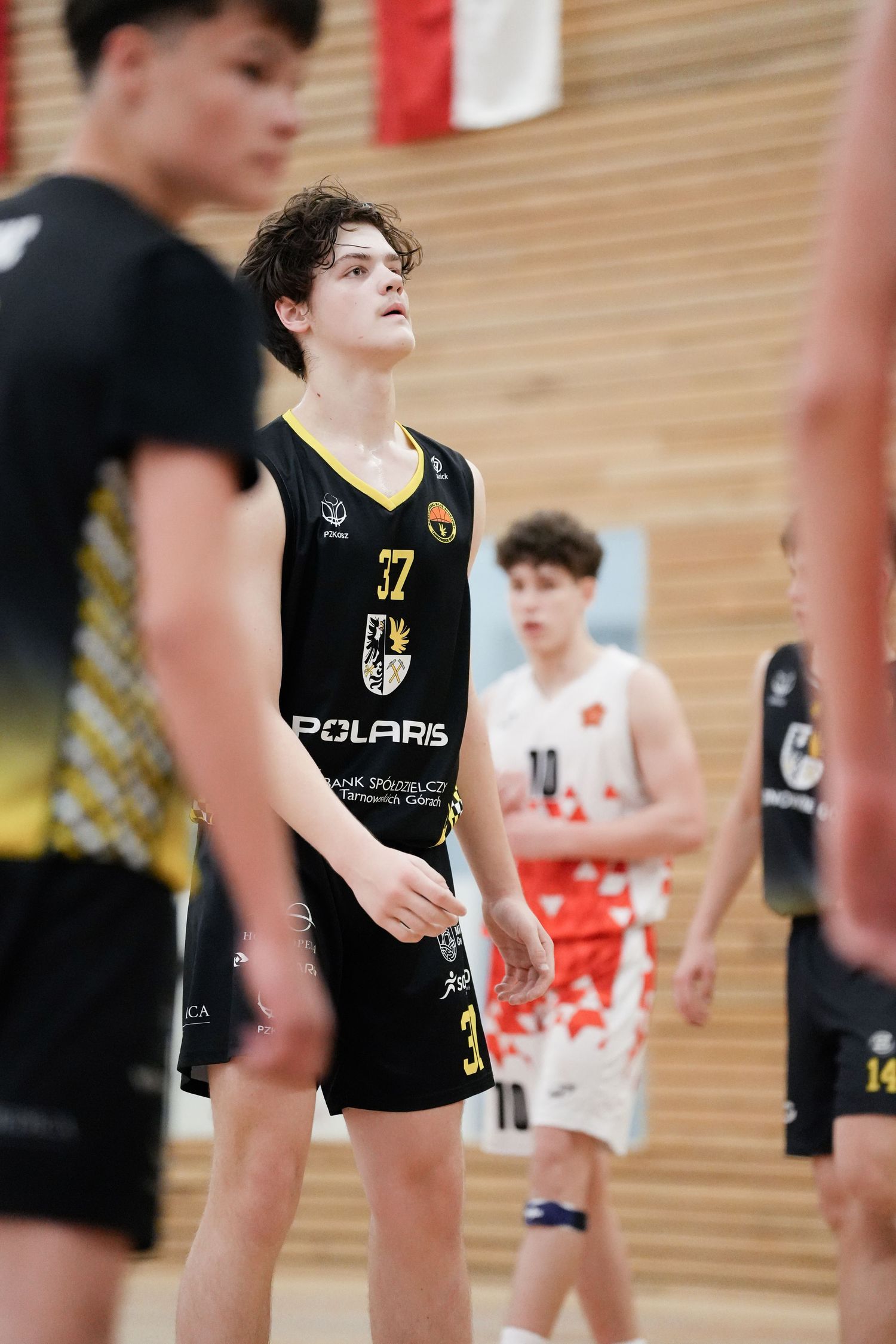 Young basketball player wearing Polaris jersey number 32 during an indoor youth basketball game.