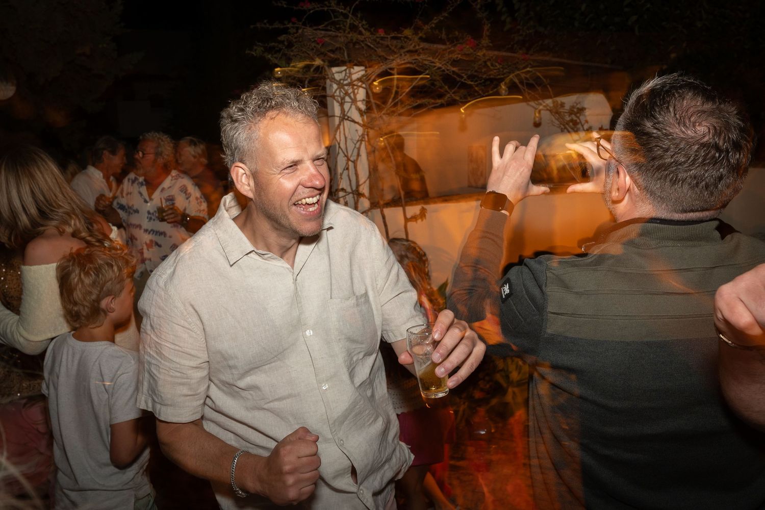 A series of candid party photos showing people dancing and celebrating in warm lighting at an evening event.