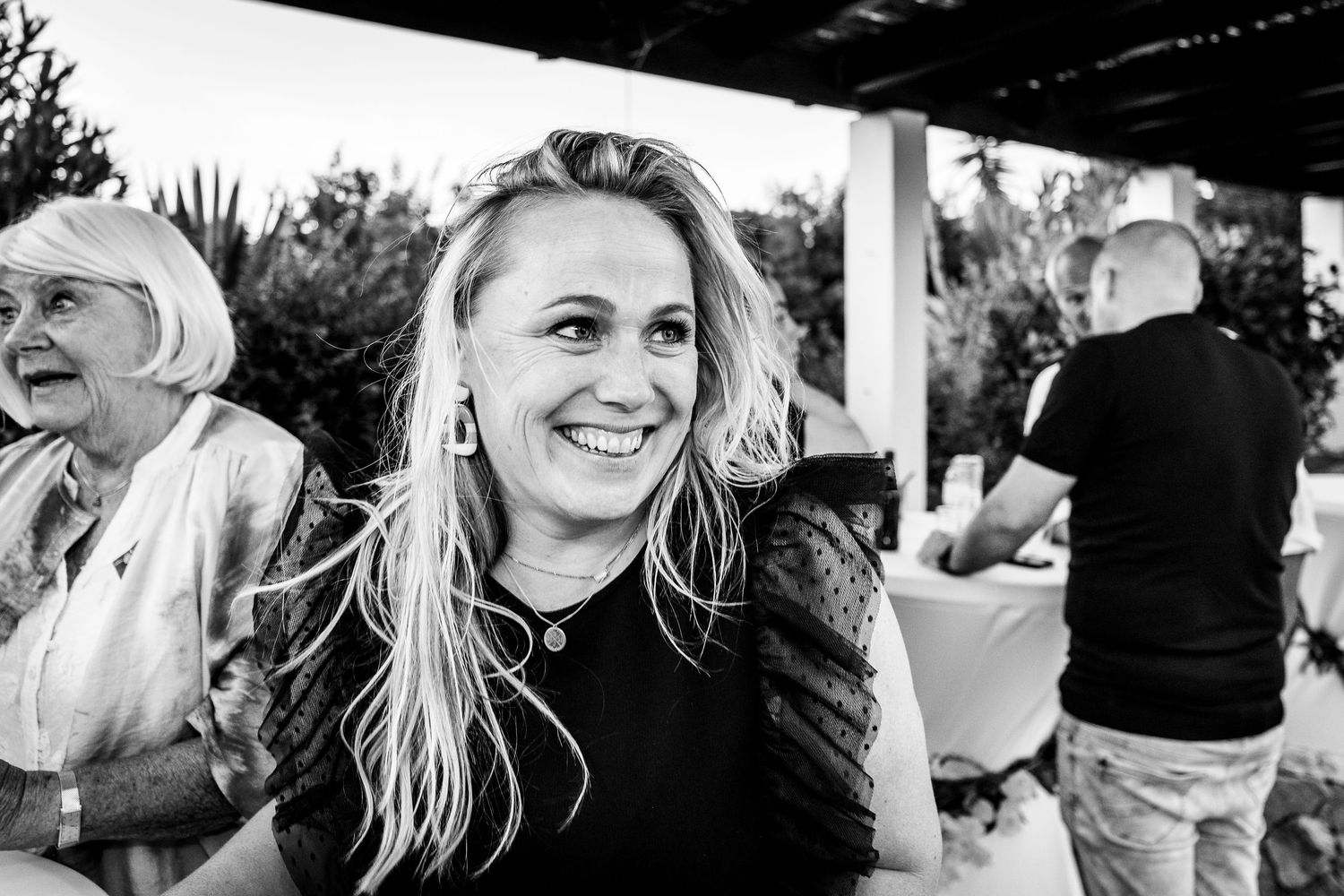 A candid black and white photo collage showing joyful expressions and spontaneous moments during a social gathering.
