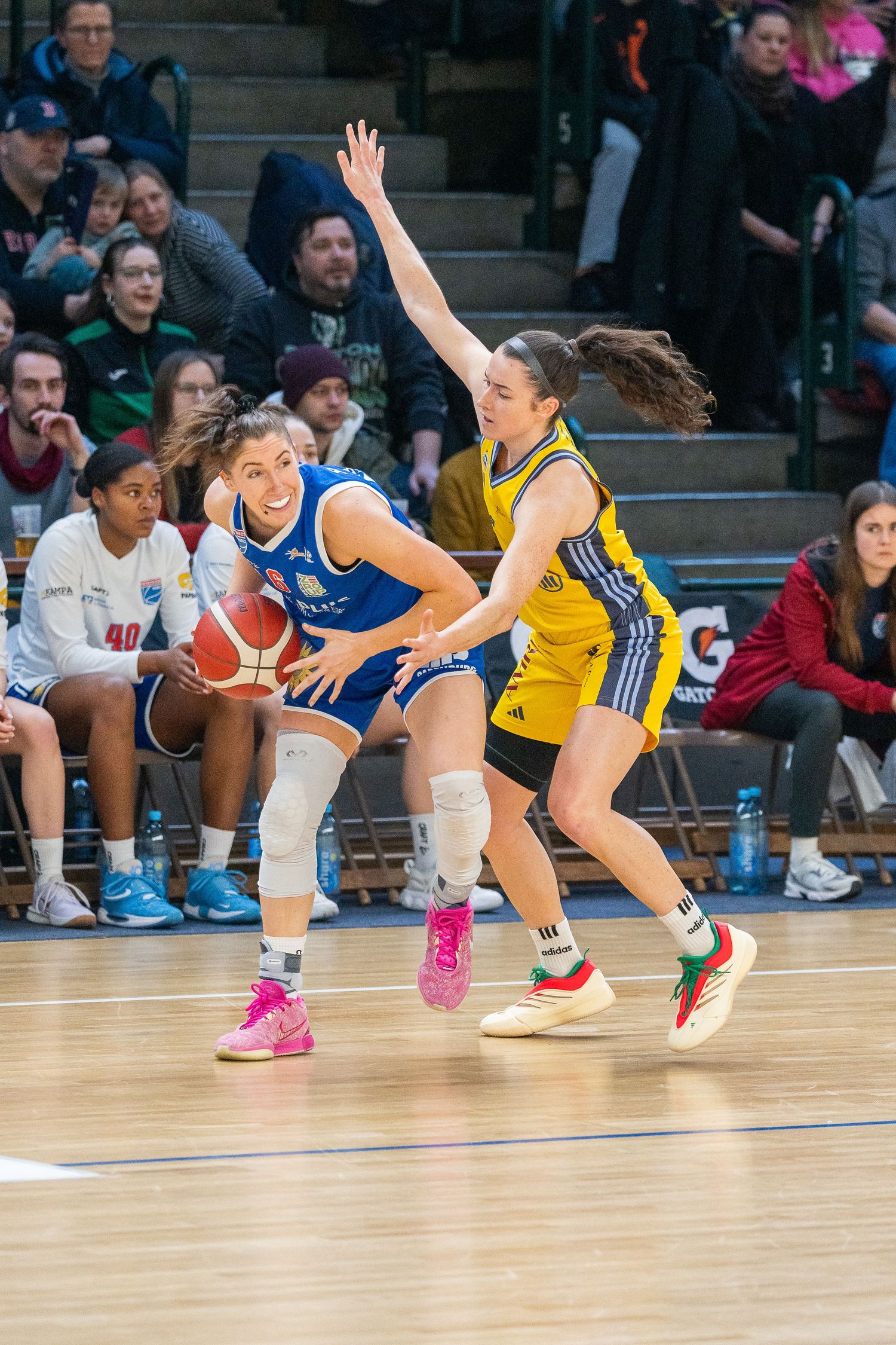 Basketball players dive and stretch across the court in dramatic sequence showing intense effort to save a loose ball.