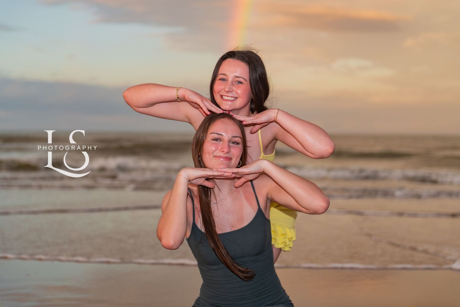 Playful beach portraits at sunset with ocean waves in background.