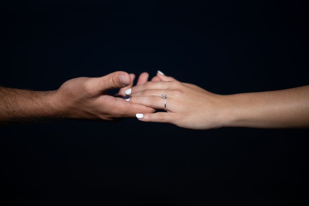 Series of hands reaching out to each other against a dark background.