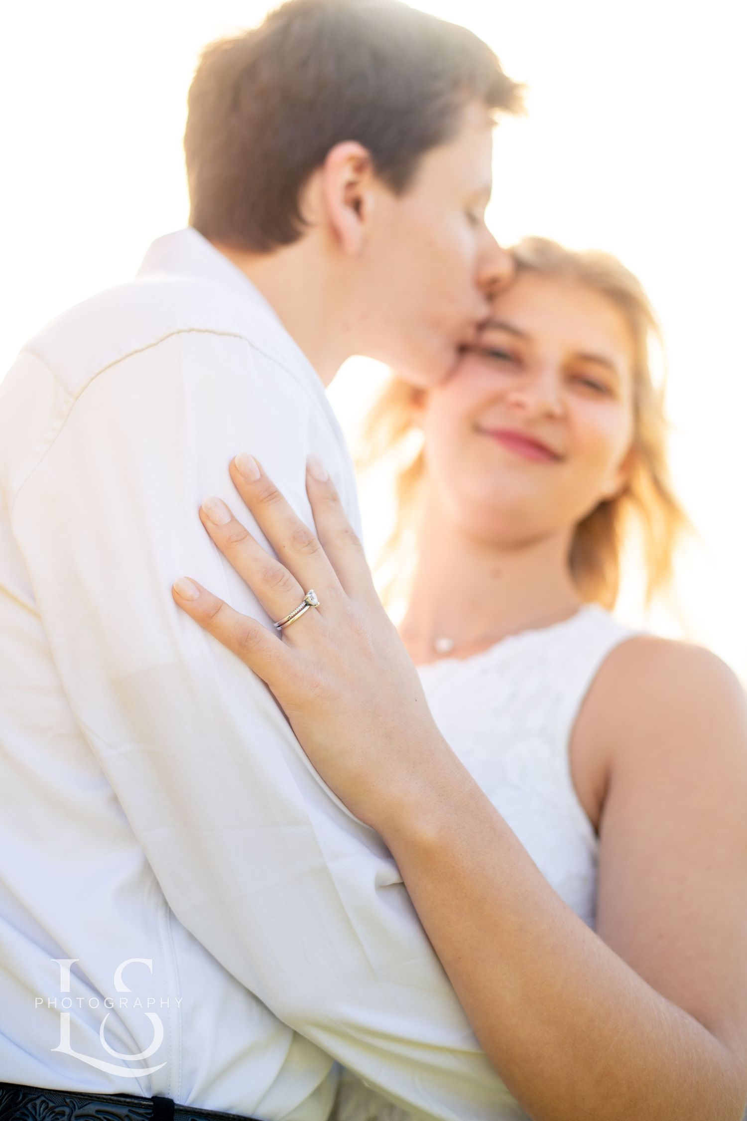 Soft focus romantic portrait showing ring detail in natural sunlight.