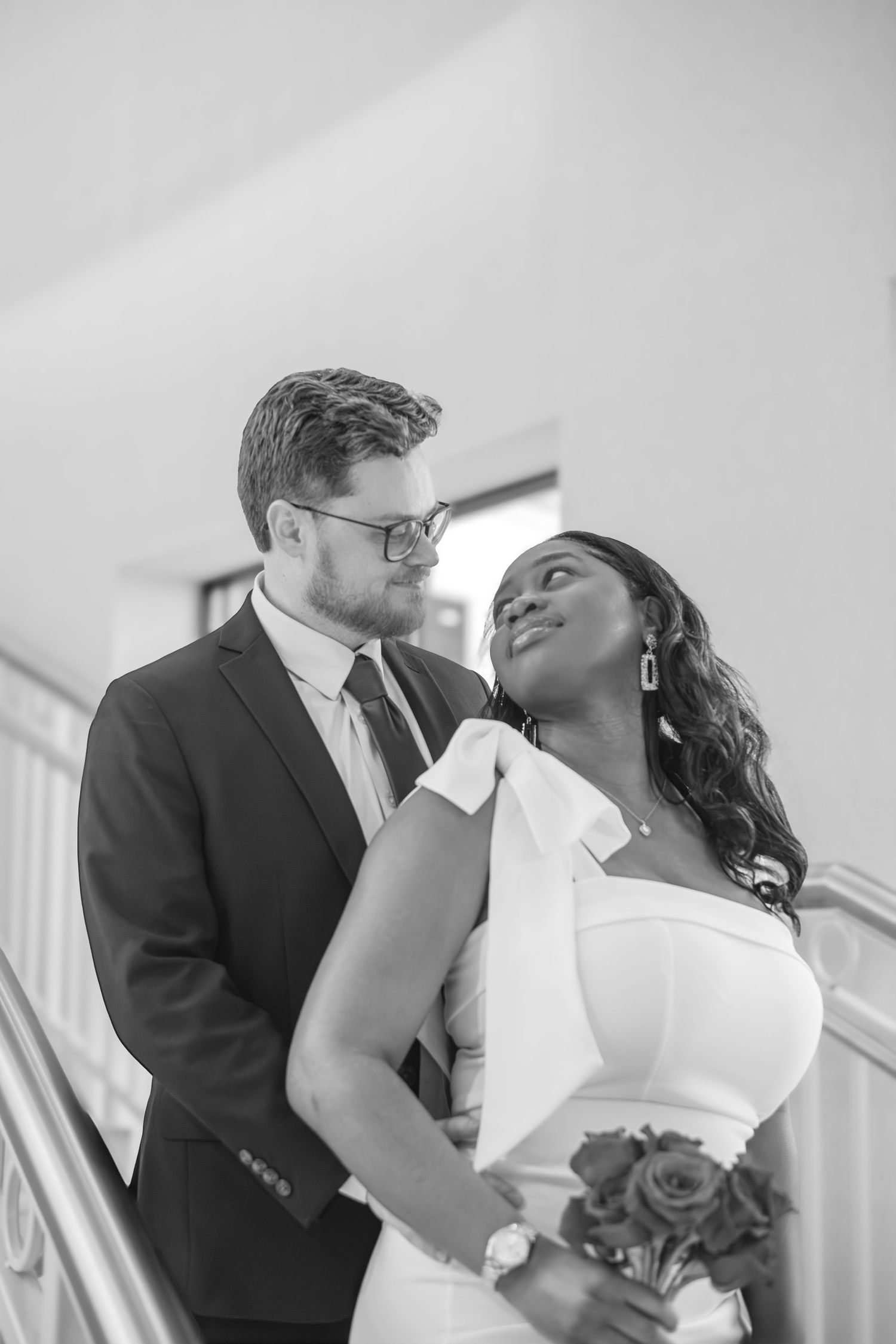 A romantic black and white wedding photo series showing a couple sharing intimate kisses in formal attire.