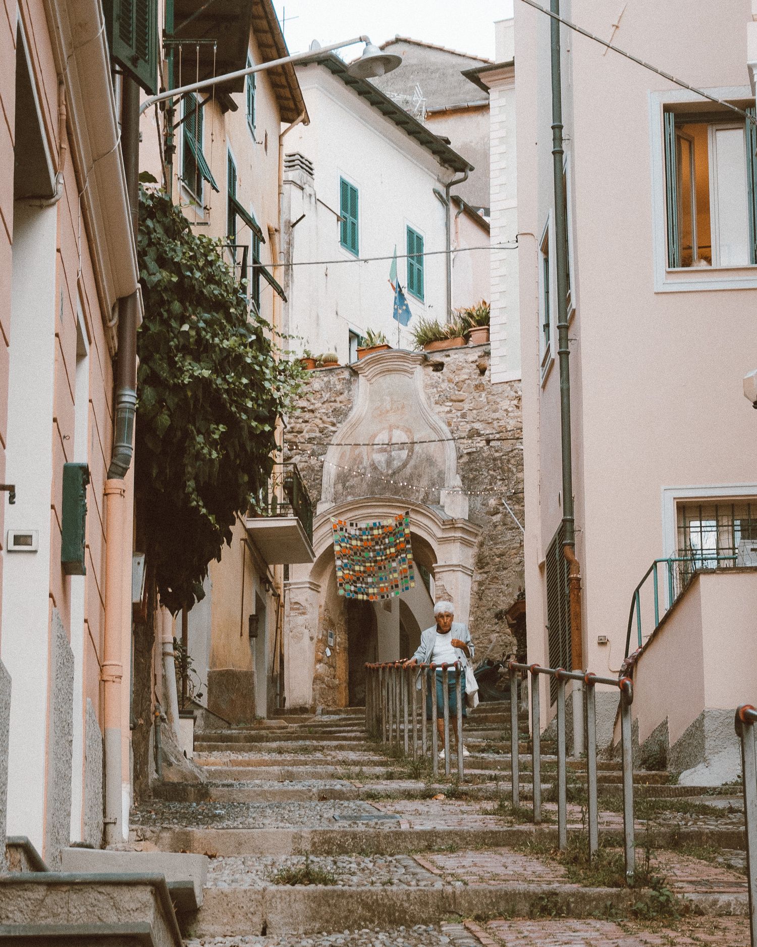 Charming narrow streets of an Italian village, with stone buildings and vibrant flowers in full bloom