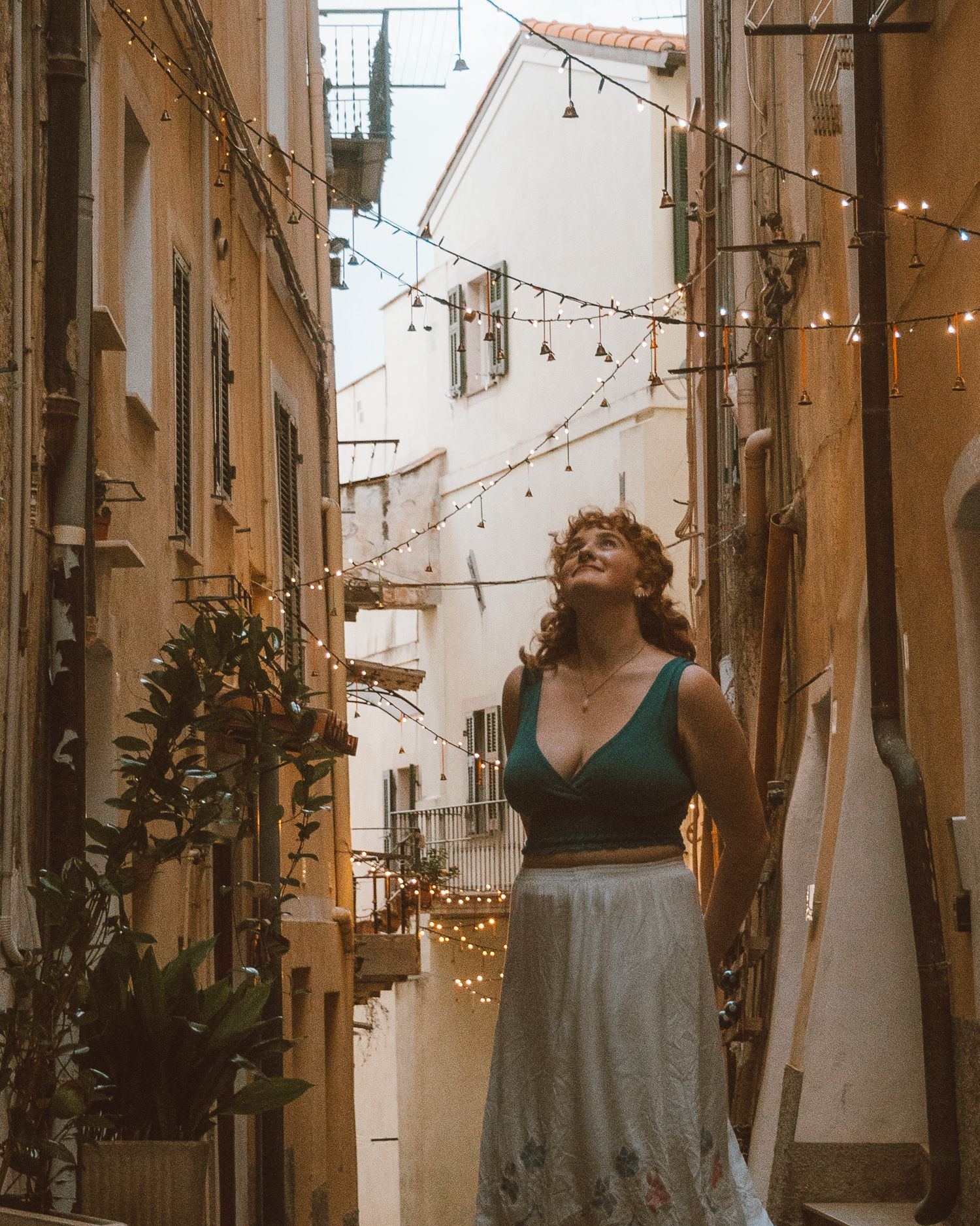 Model walking through the warmly lit streets of an Italian village.