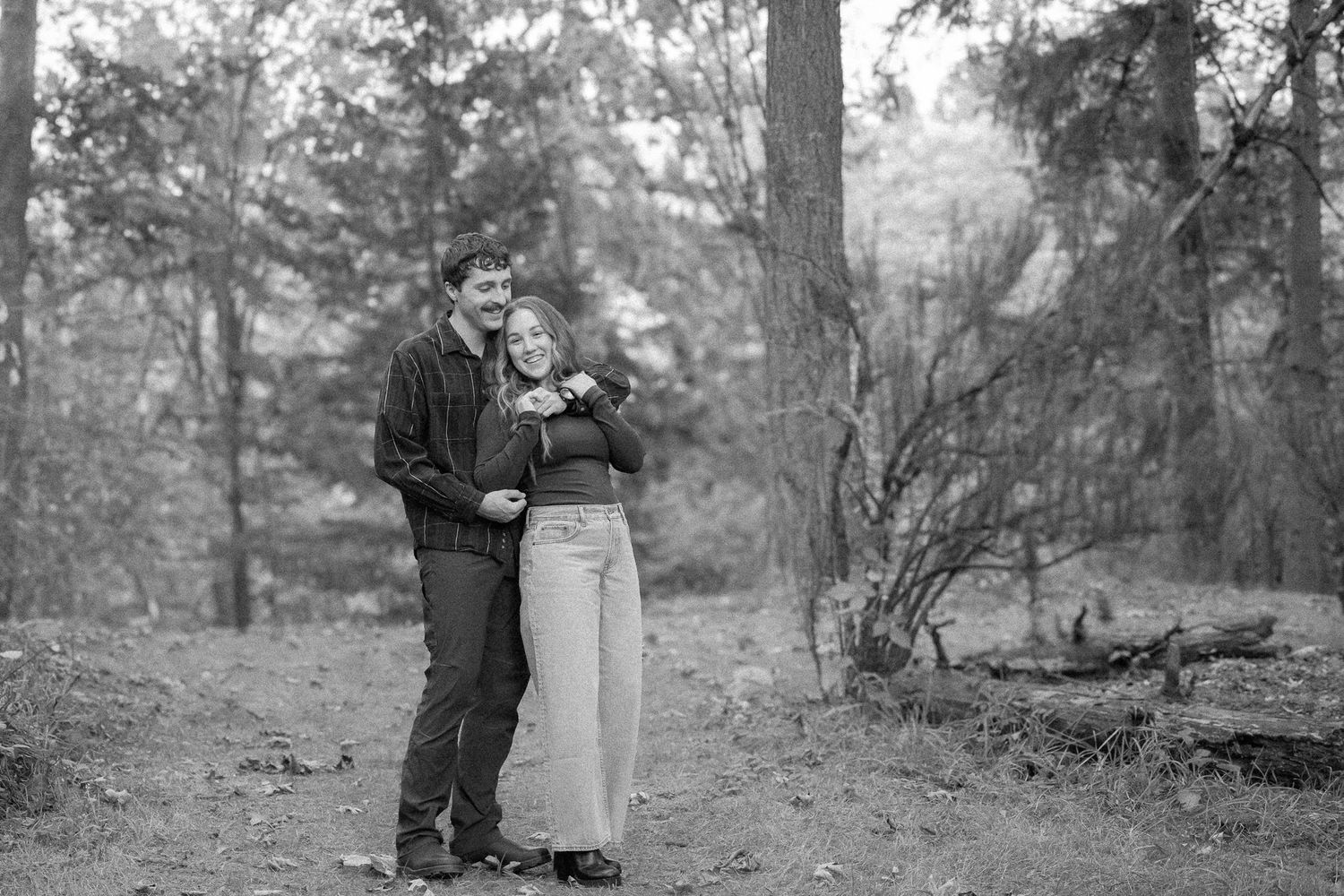 Couple in an intimate embrace, captured during a candid moment of joy in a scenic outdoor setting.