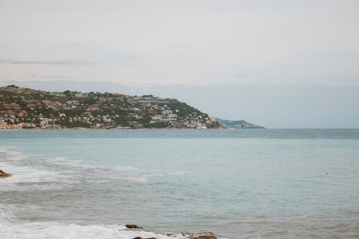 Photograph of a sunset over the ocean, with soft light casting reflections on the water and a peaceful, tranquil vibe.