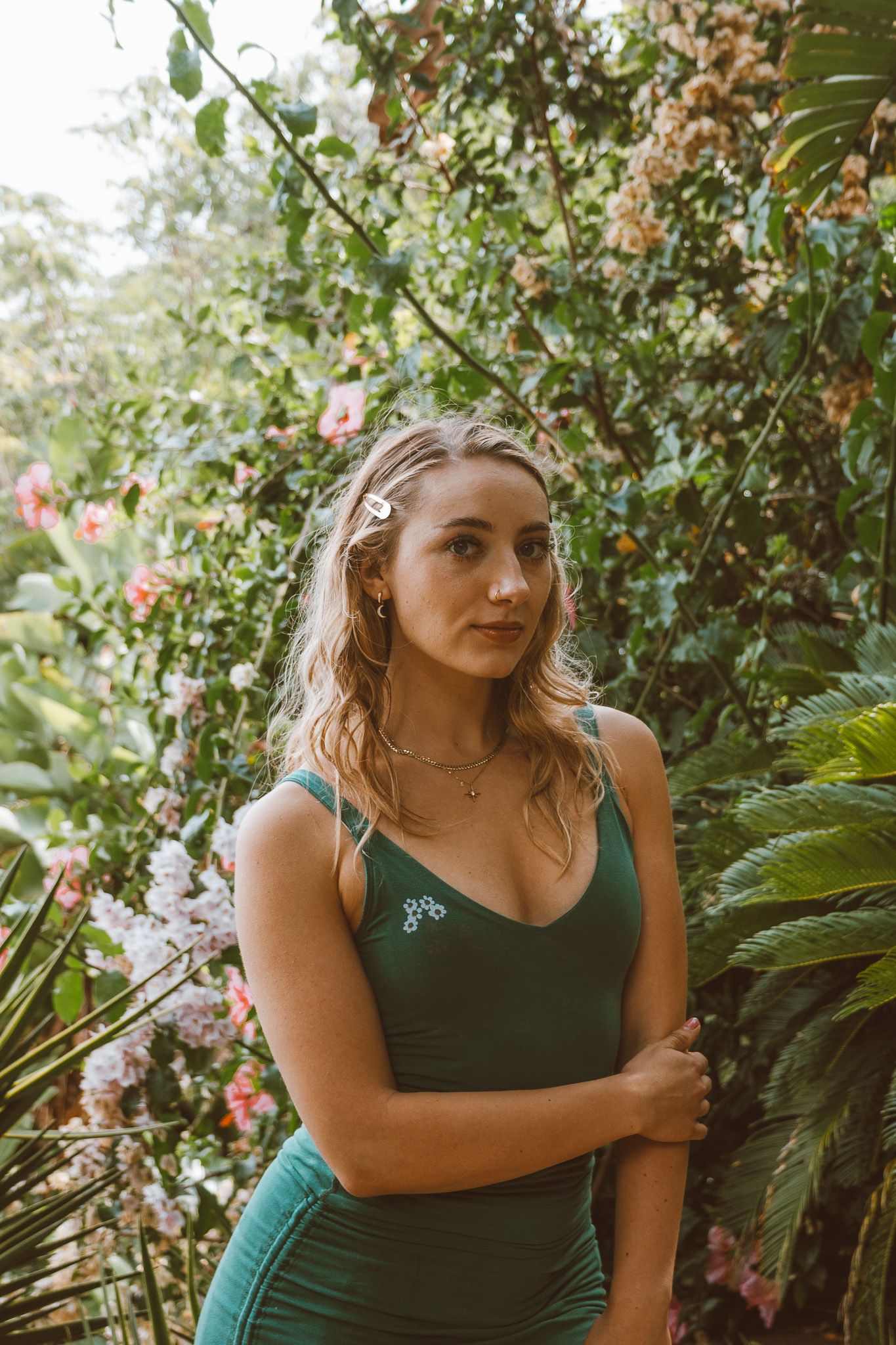 A model posing in an open field during golden hour, with natural light highlighting their relaxed, confident expression