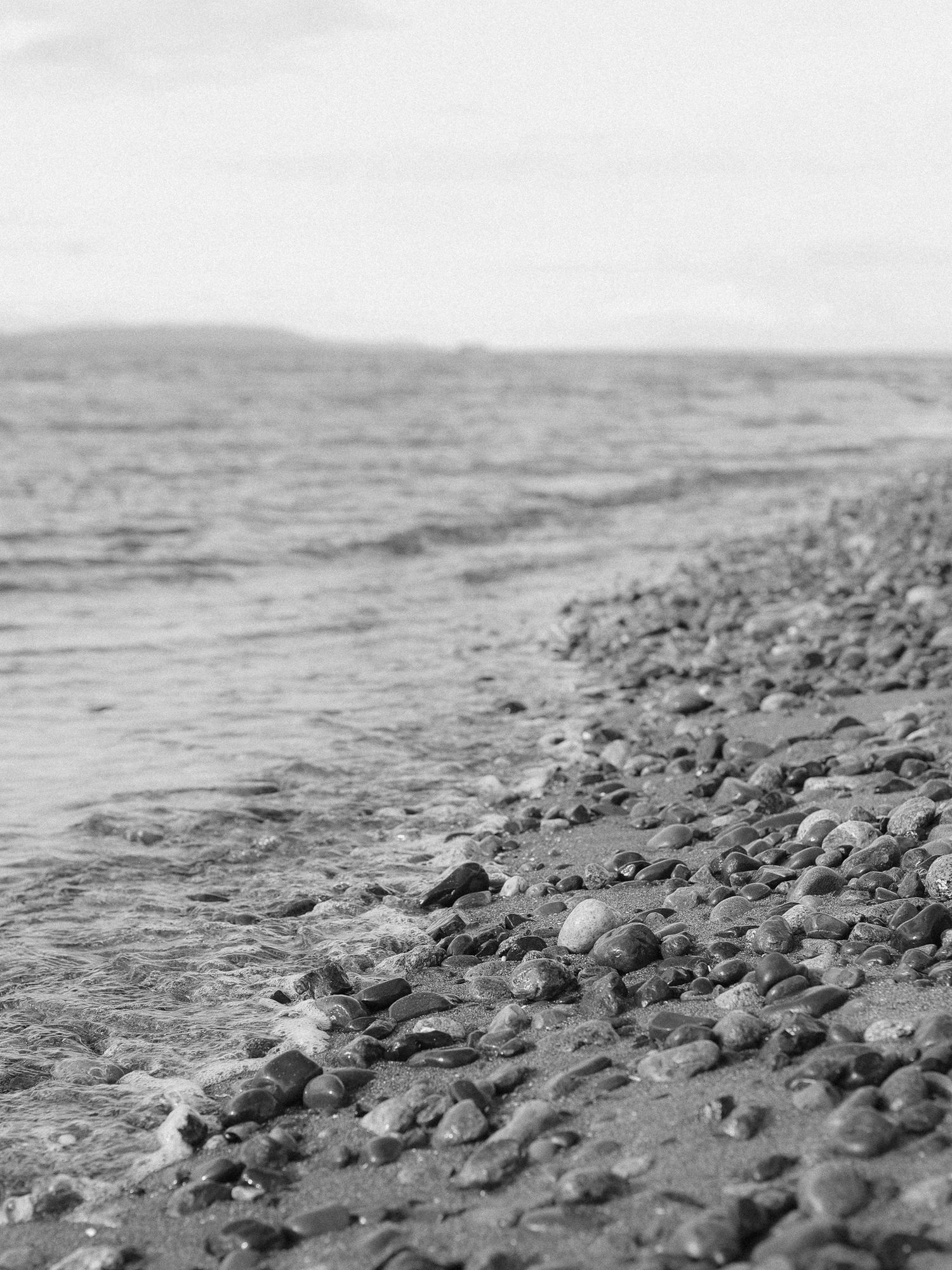 Black and white photo of a rocky beach in Seattle Washington.
