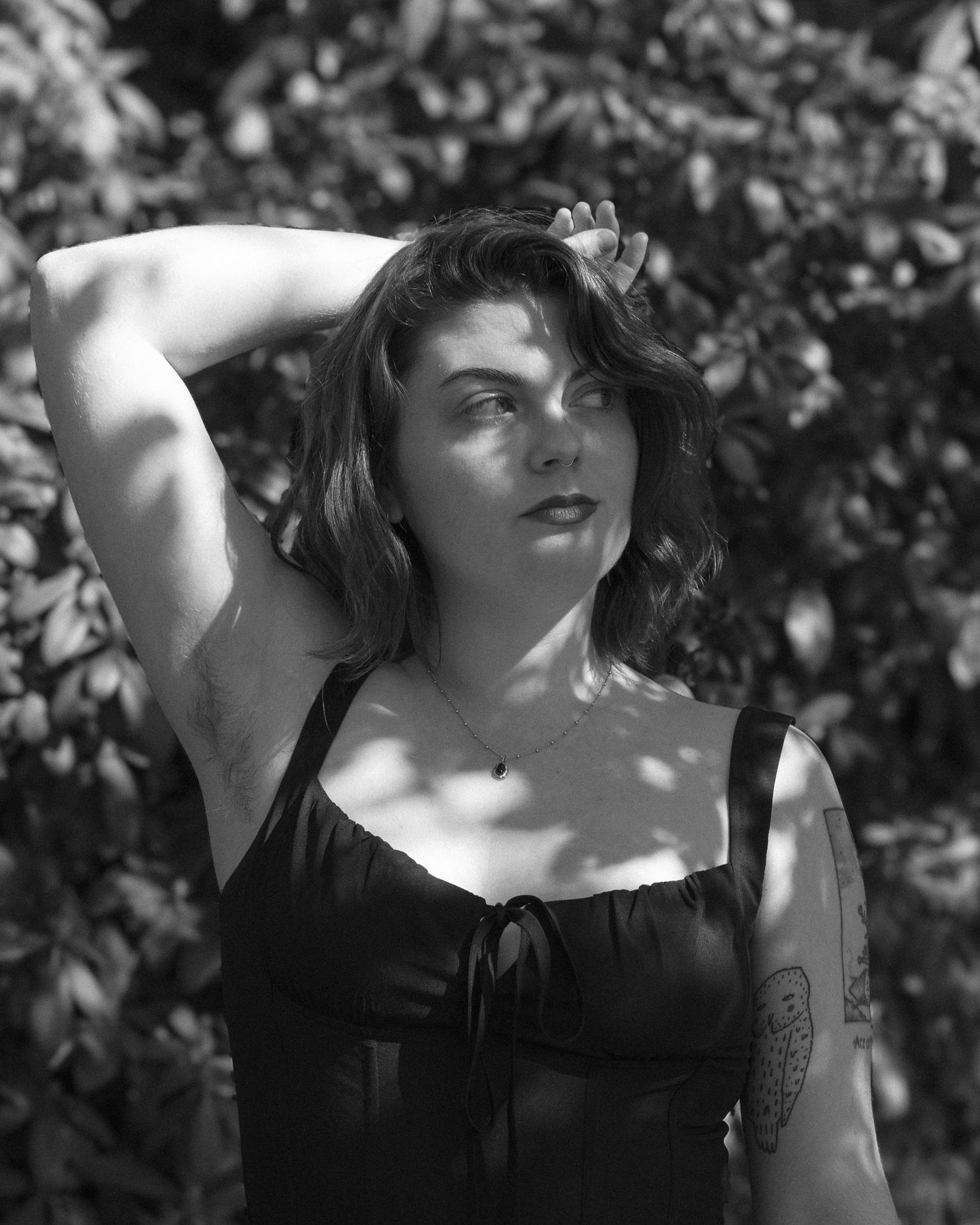 Outdoor shot of a model standing in a sunlit field, with gentle wind adding movement to their outfit