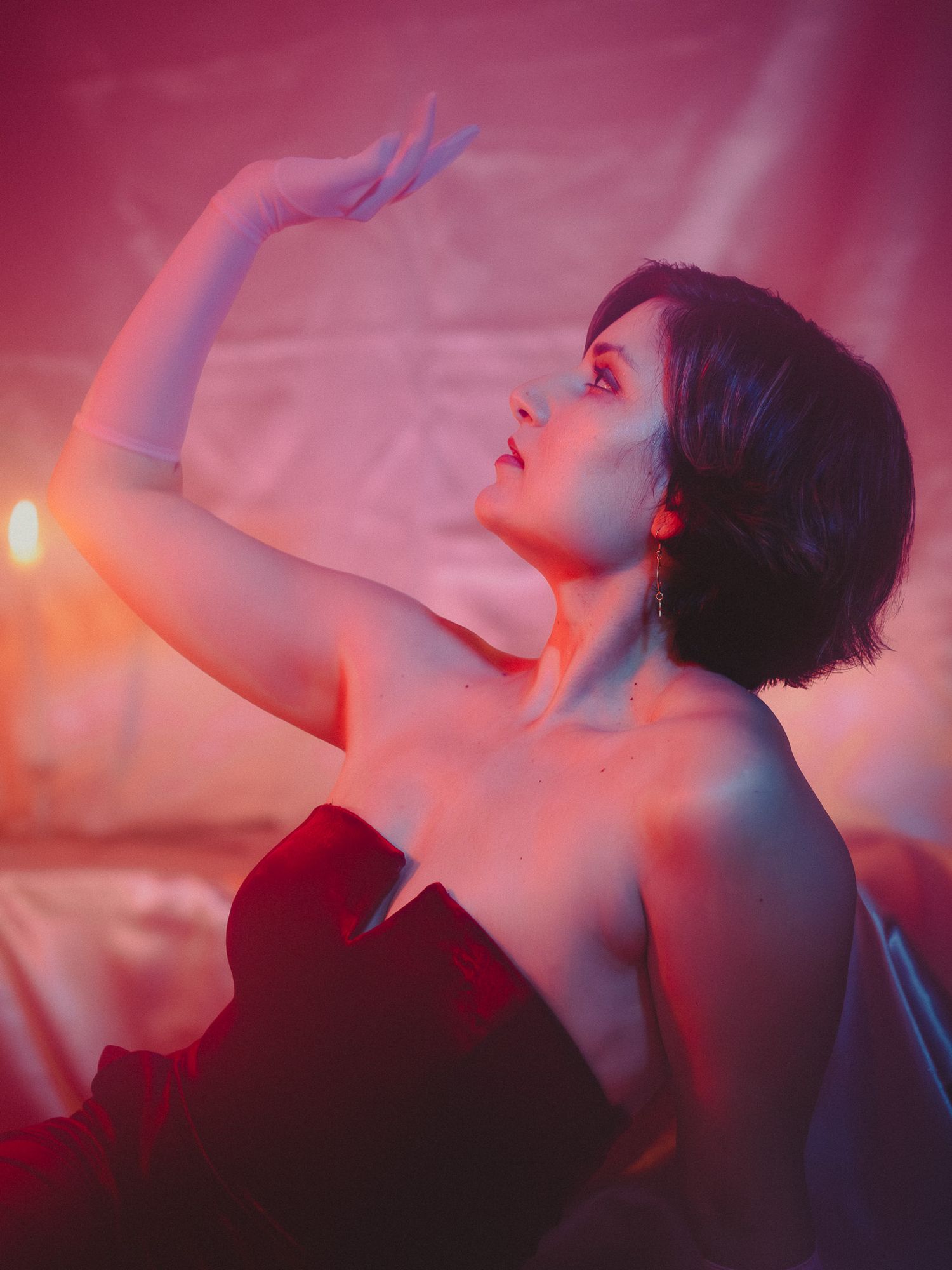 Close-up of a model in couture, striking a fierce pose with elegant lighting that accentuates the outfit's details