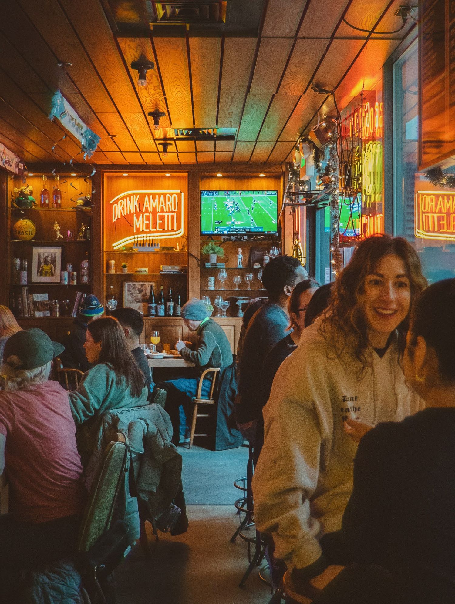 Cozy interior of a rustic tavern, with dim lighting highlighting the wooden bar and patrons enjoying drinks in a warm, inviting atmosphere