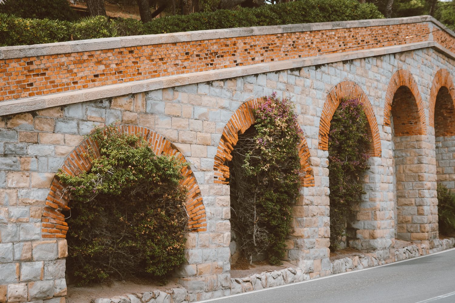 Scenic view of a traditional Italian village, with terracotta rooftops and lush greenery surrounding it.