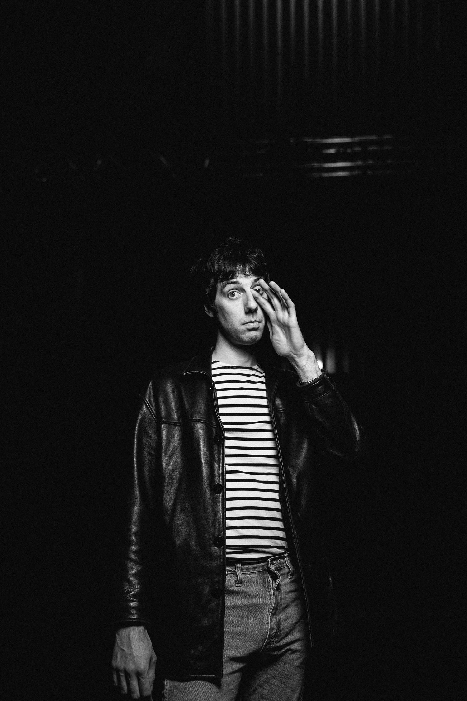 A dramatic black and white portrait series showing someone wearing a striped shirt and leather jacket against dark shadows.