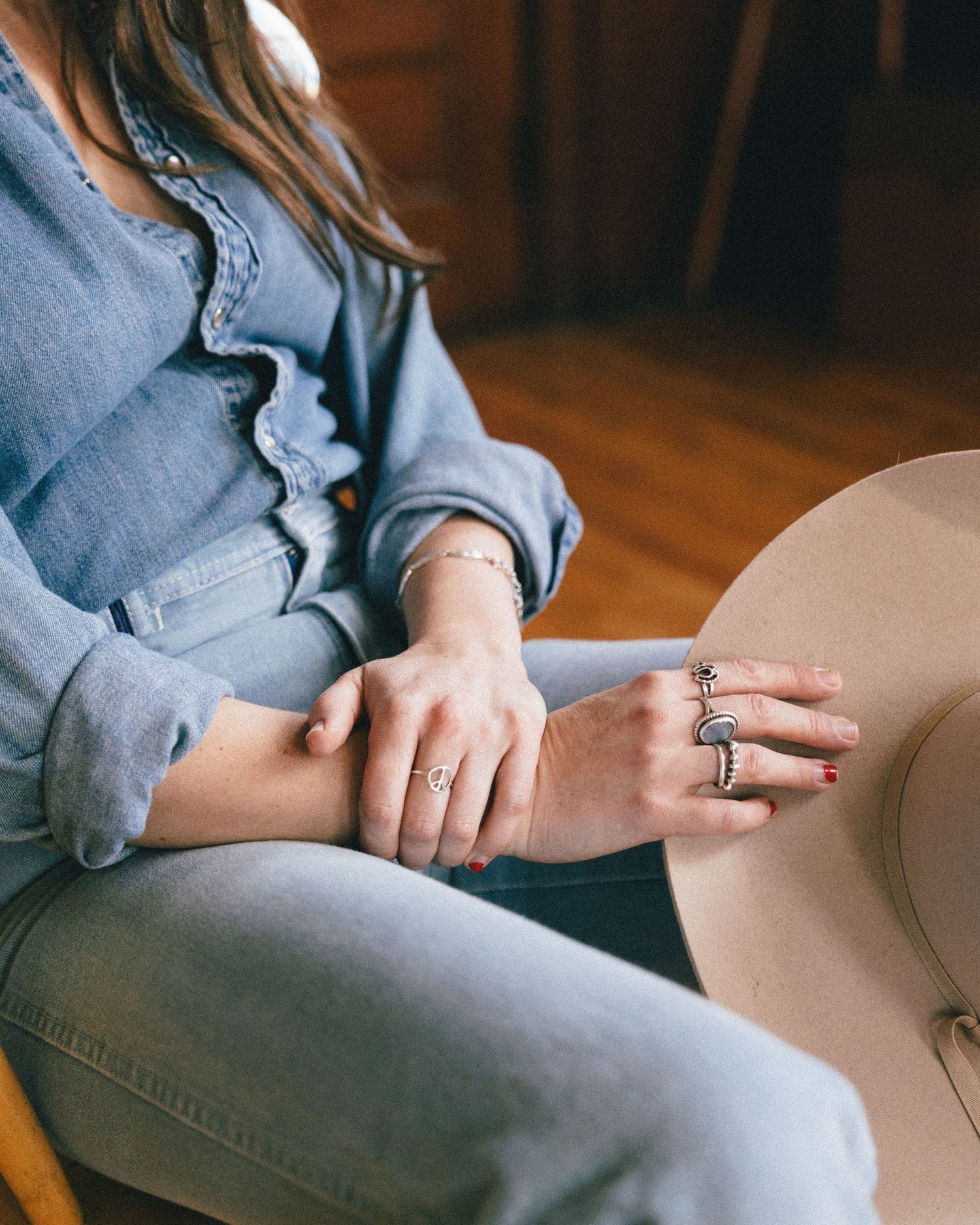 Close-up sequence of hands wearing rings resting on beige fabric in a home setting.