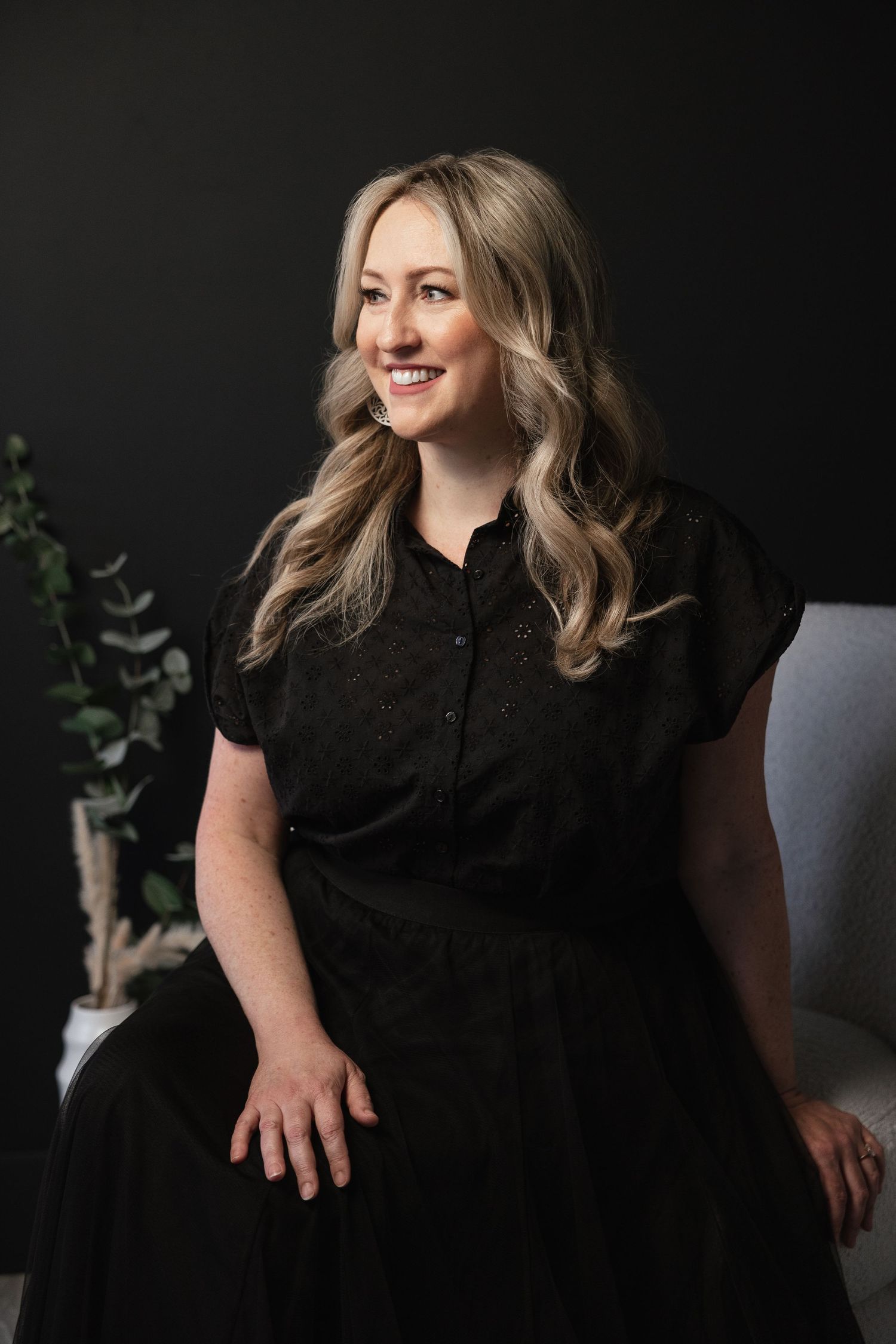 Professional bridal boutique photoshoot against dark background featuring elegant black attire.