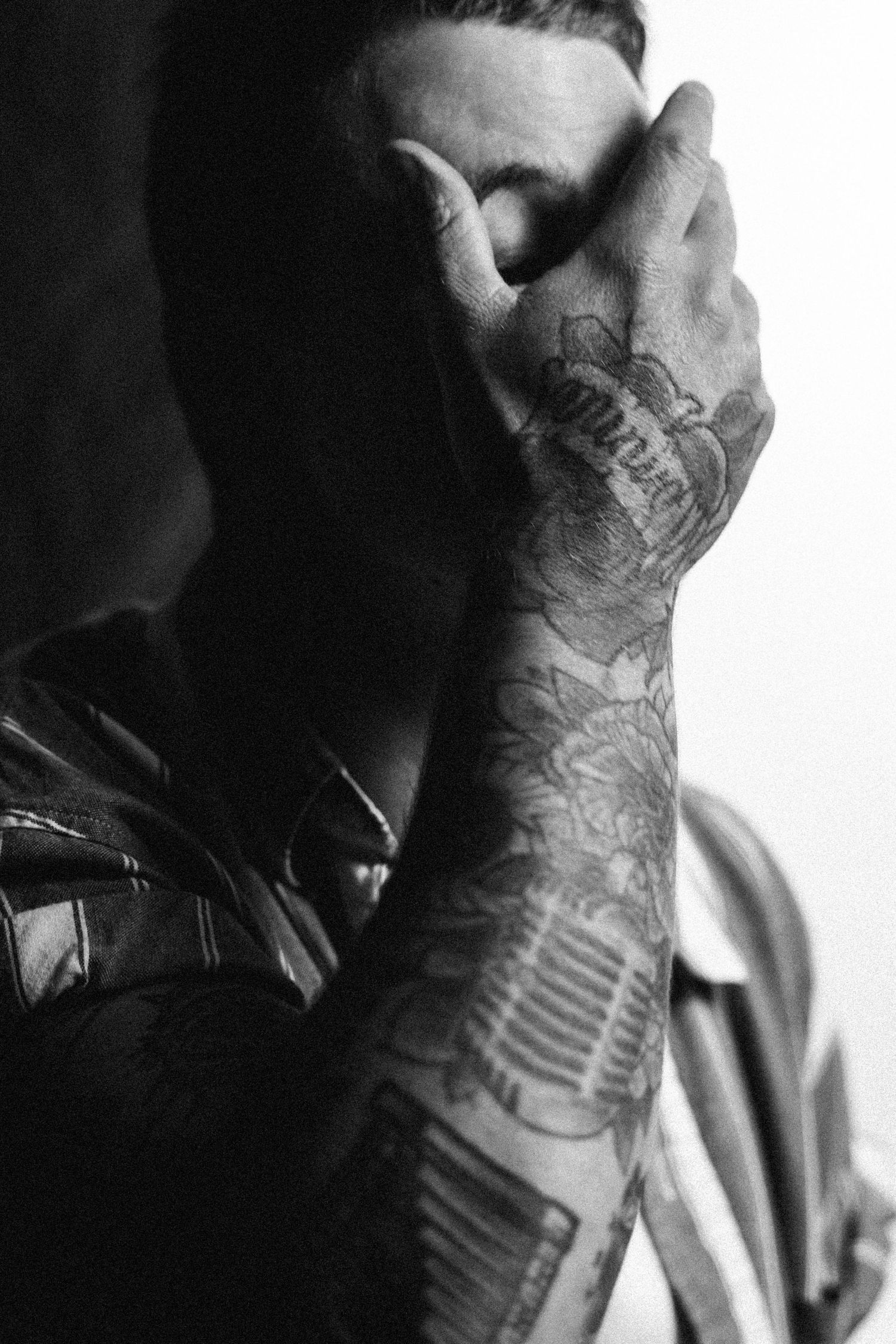 Black and white series of photographs showing a detailed skeletal hand tattoo design on someone's forearm.