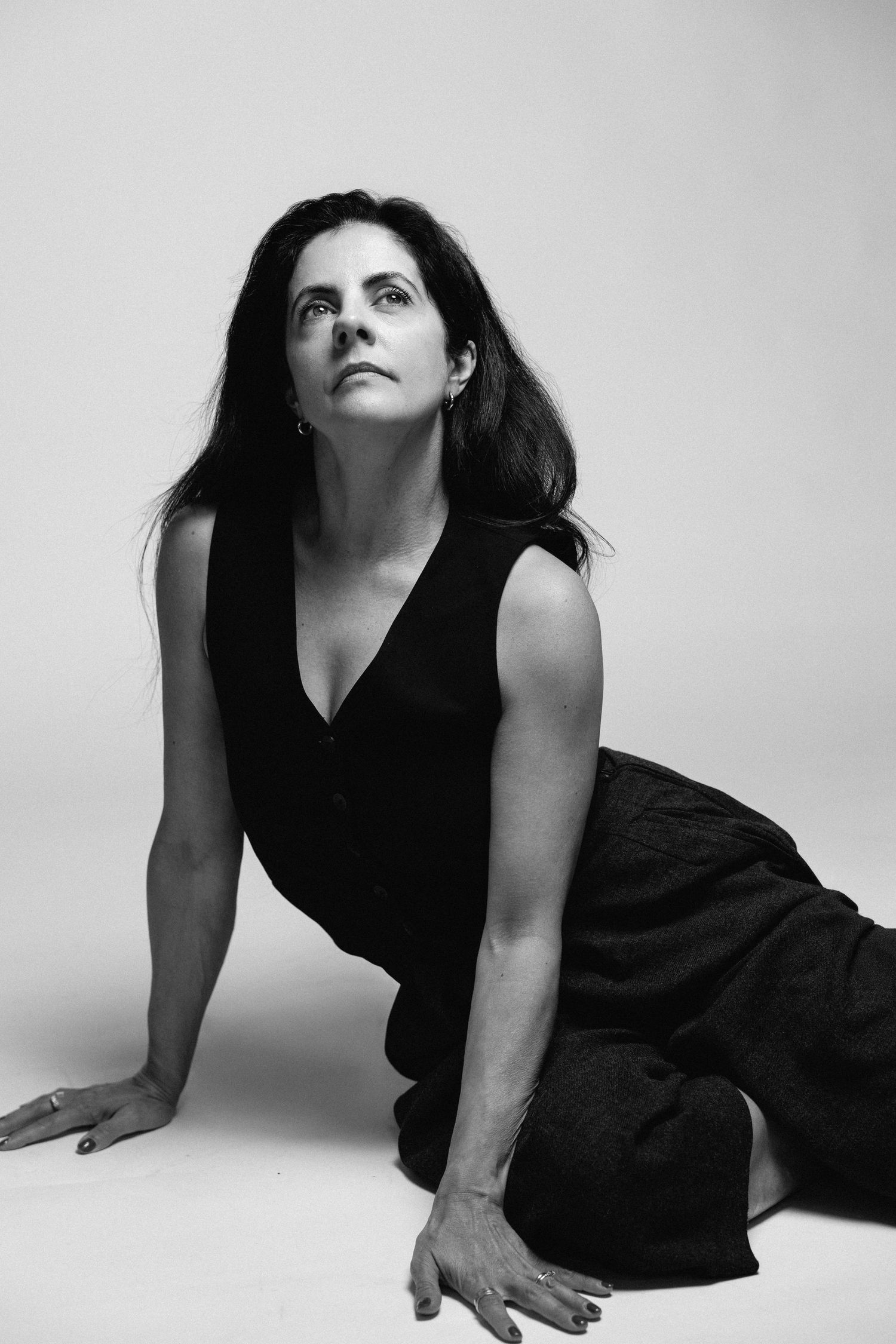 A series of dramatic black and white portraits showing a person in a black dress posing against a white background.
