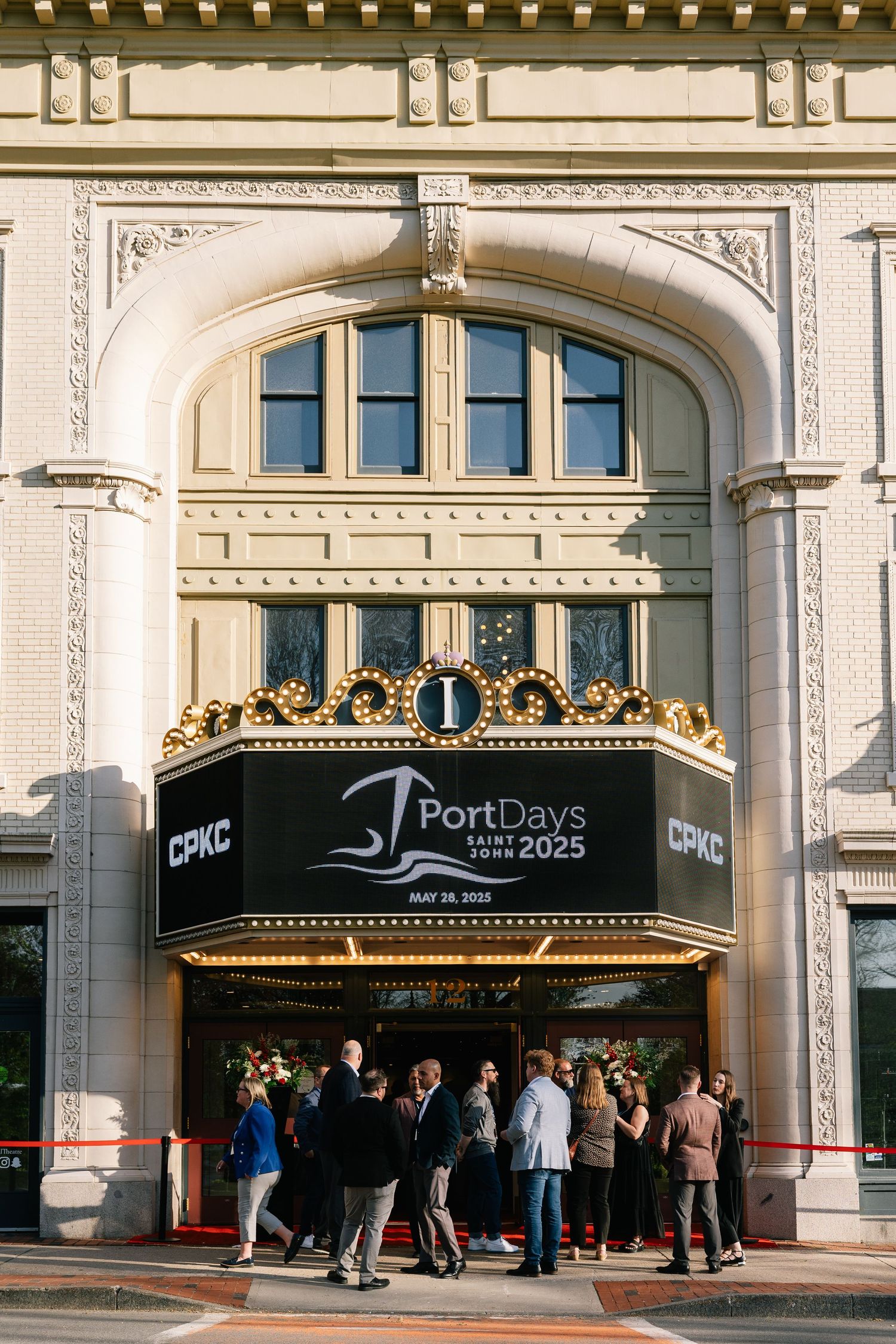 People gather at entrance of historic theater with ornate architecture displaying Port Days 2023 signage on marquee.
