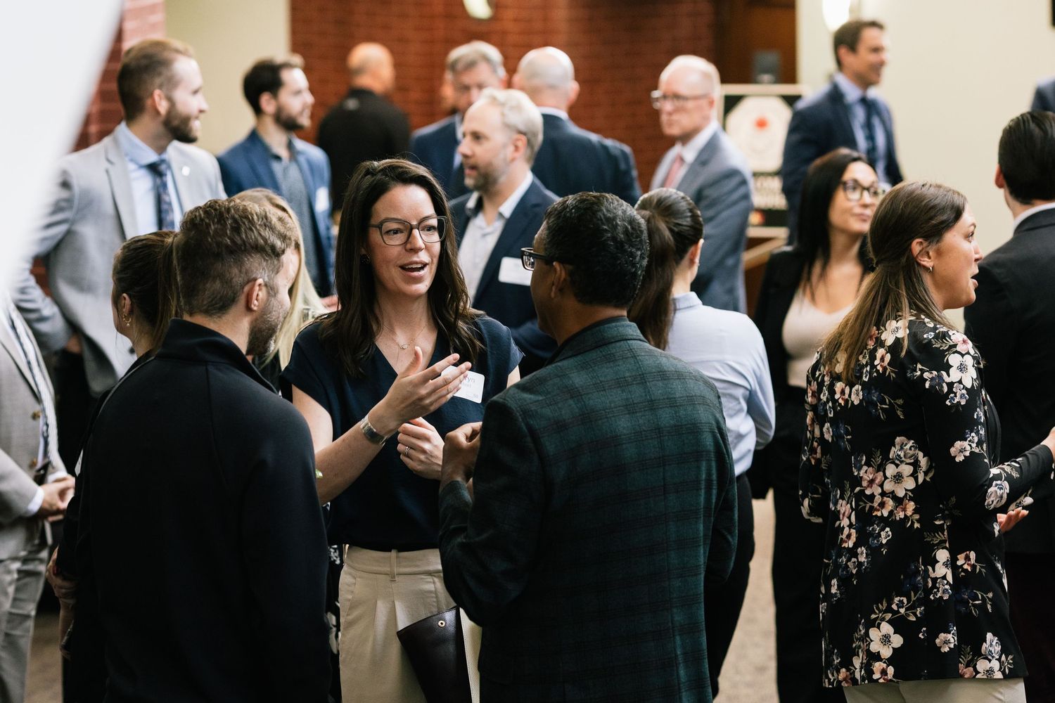 Crowd of business professionals networking and mingling at a corporate event.