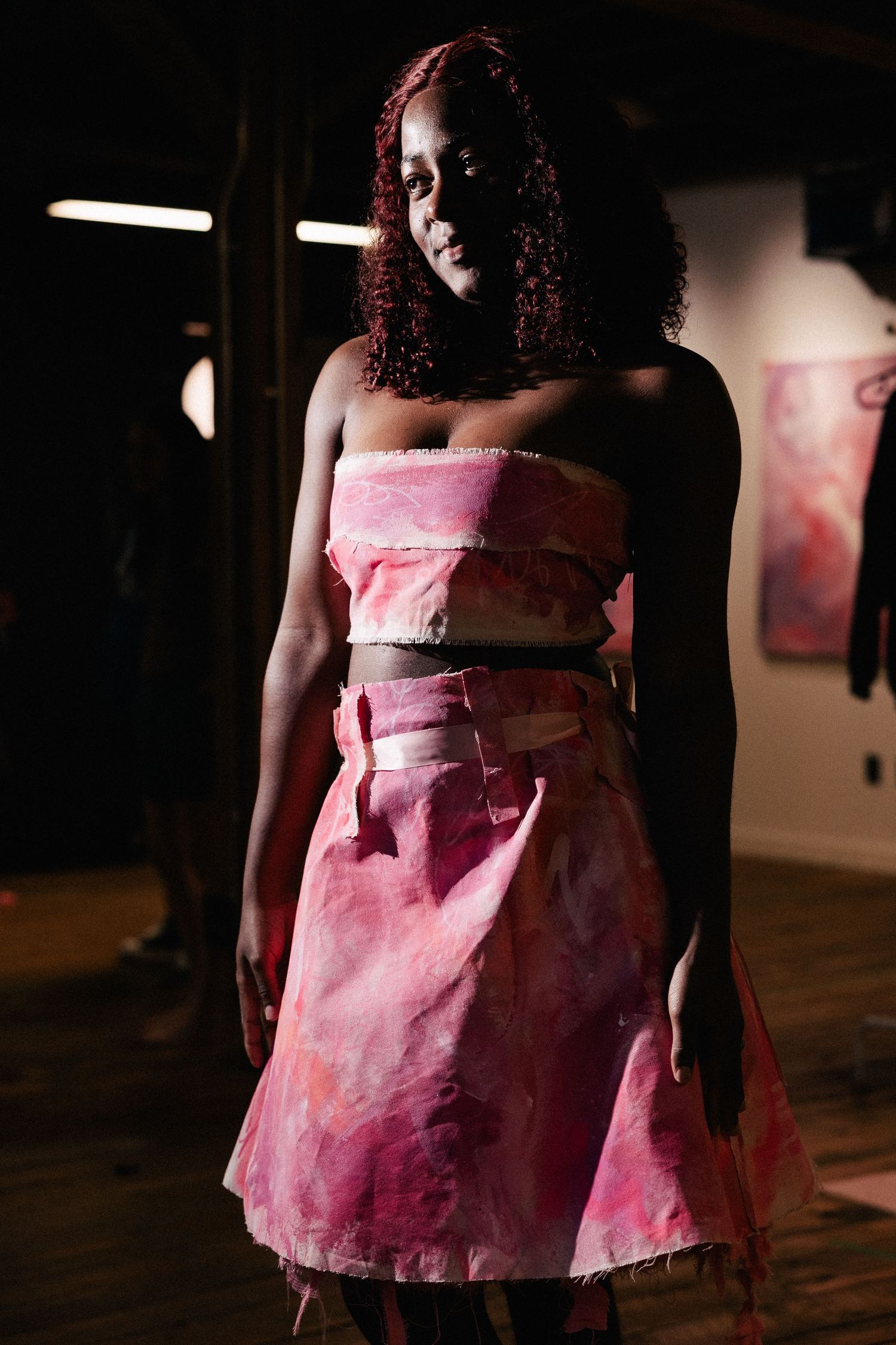 A series of cropped photos showing pink and burgundy watercolor-stained dress fabric details in a dimly lit space.