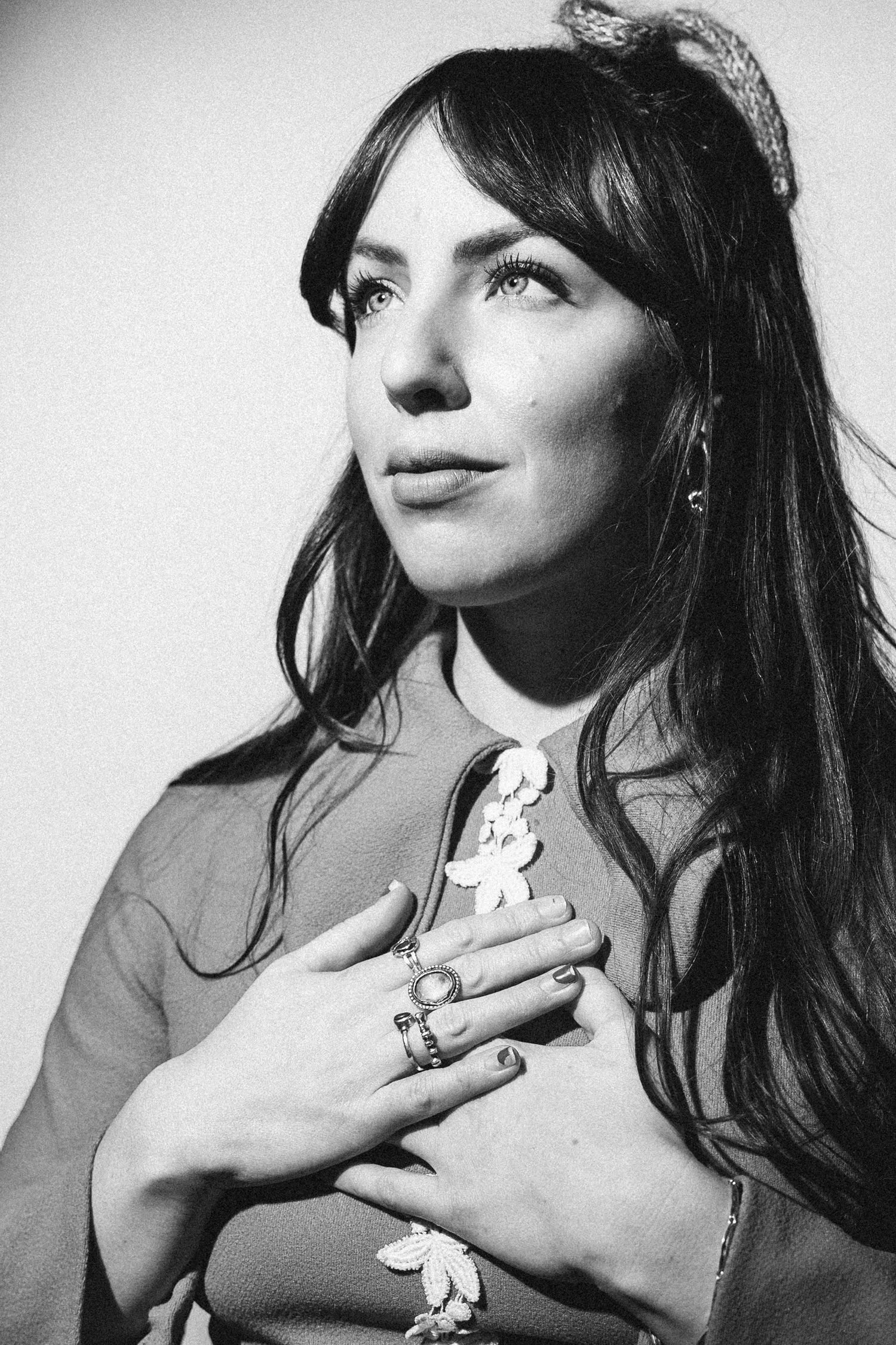 Black and white portrait of a woman in profile wearing hair accessories and floral embellished clothing.