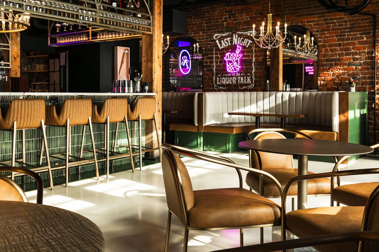 Modern bar interior with leather barstools, neon signs, exposed brick walls and ambient lighting.