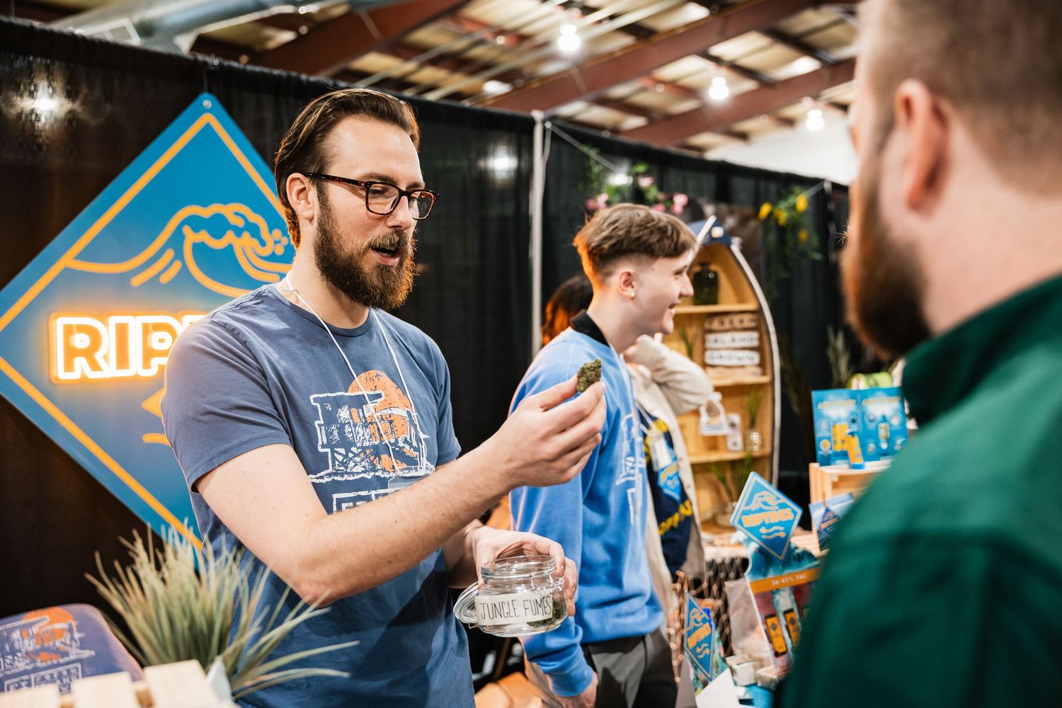 People at a craft beer vendor booth interact and sample beverages at a festival or event.
