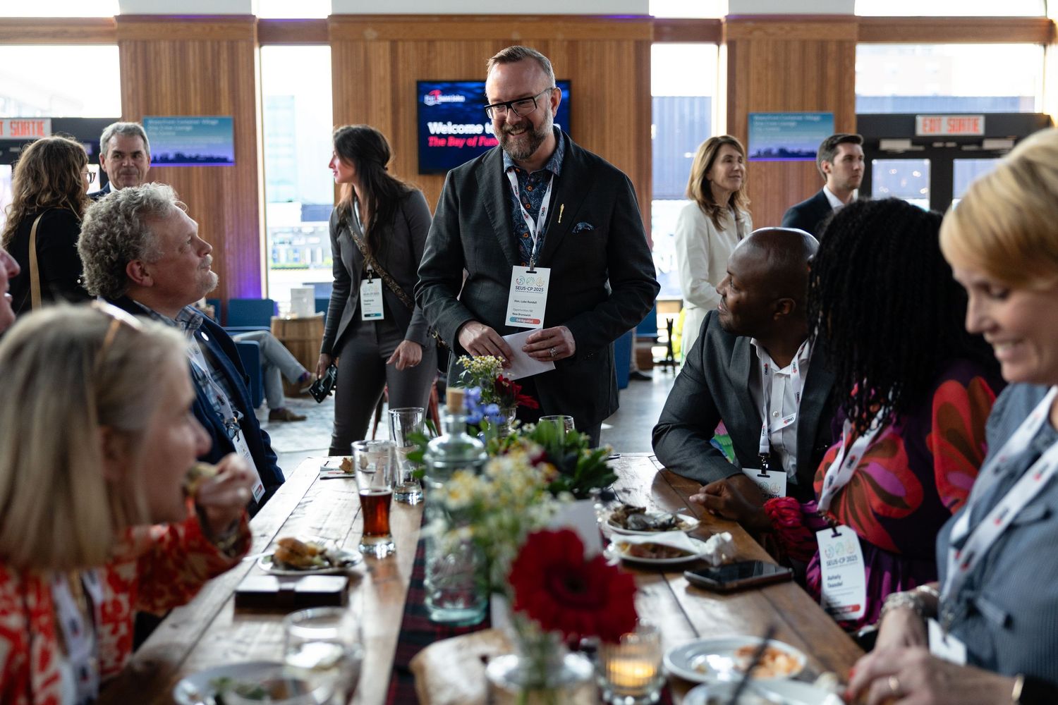 Business professionals engaged in networking and conversation during a conference lunch meeting.