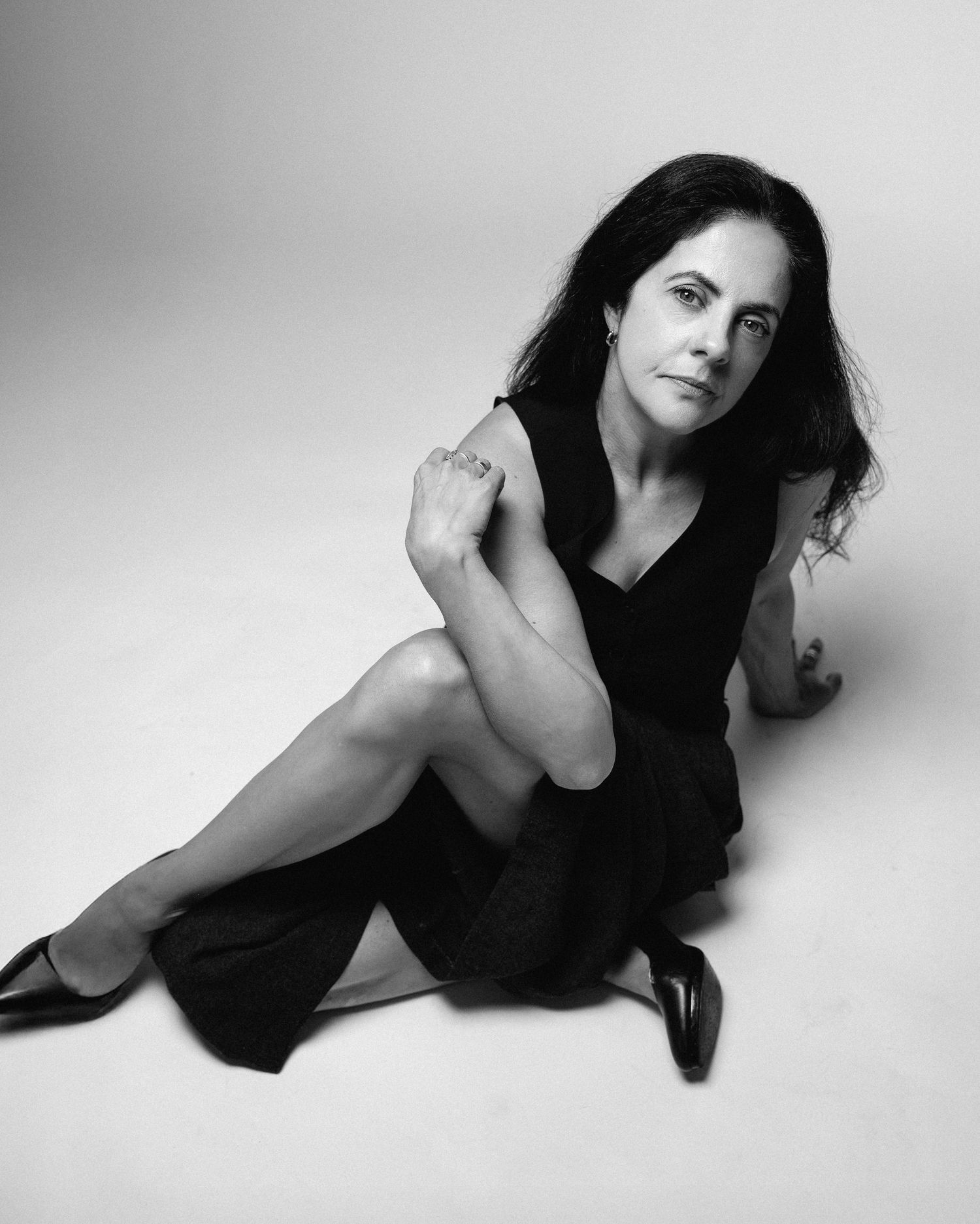 Black and white artistic portrait series showing a woman in various reclining poses against a minimalist background.