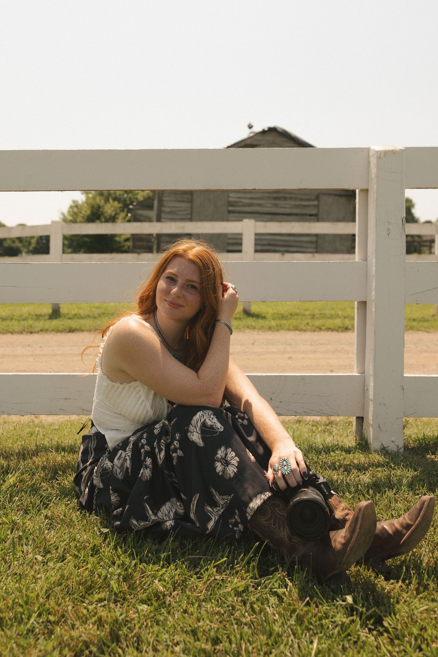 A relaxed outdoor portrait session by a white fence in golden sunlight.