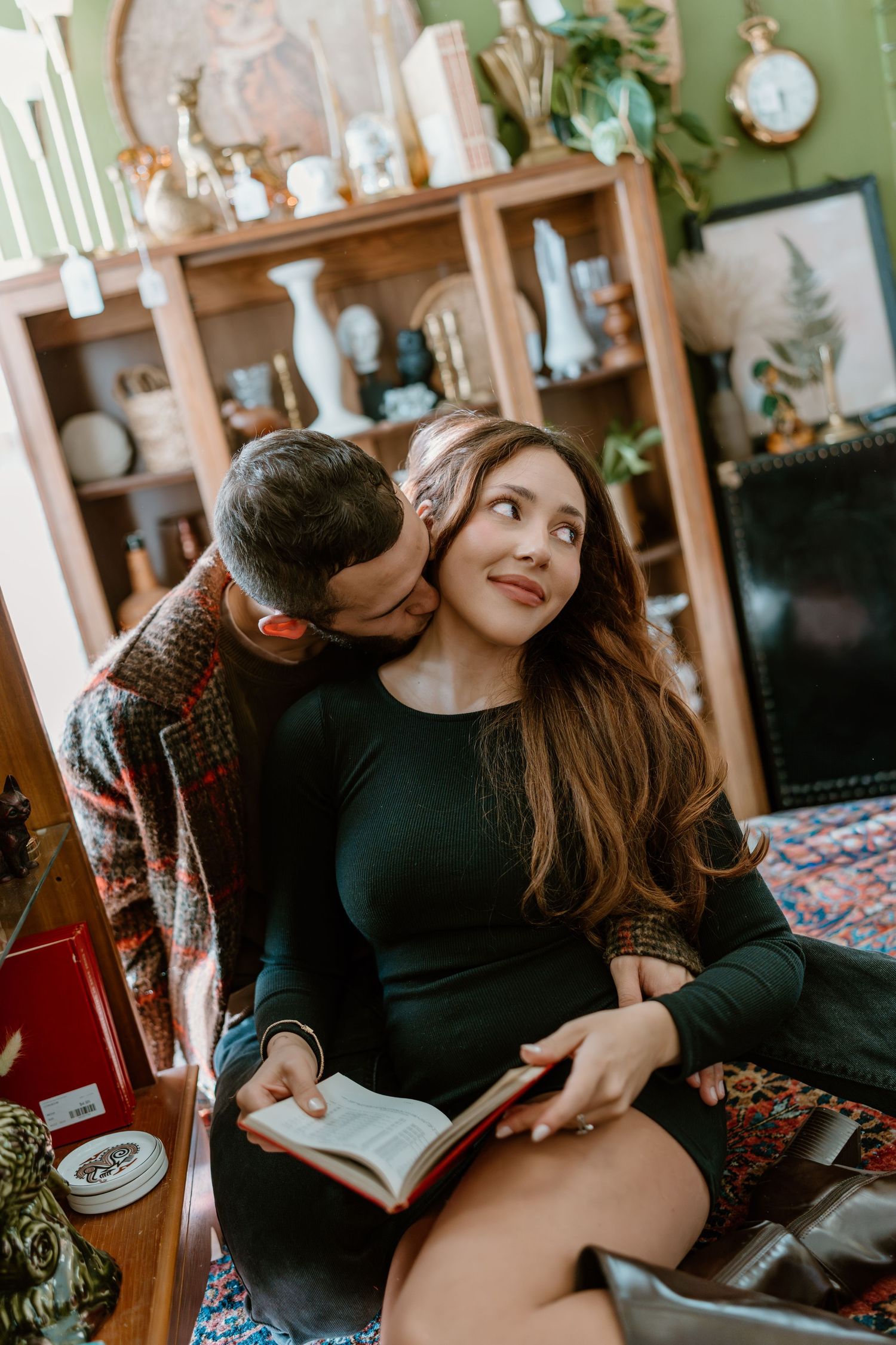 A couple shares intimate moments while sitting together on a couch in a cozy living room setting.