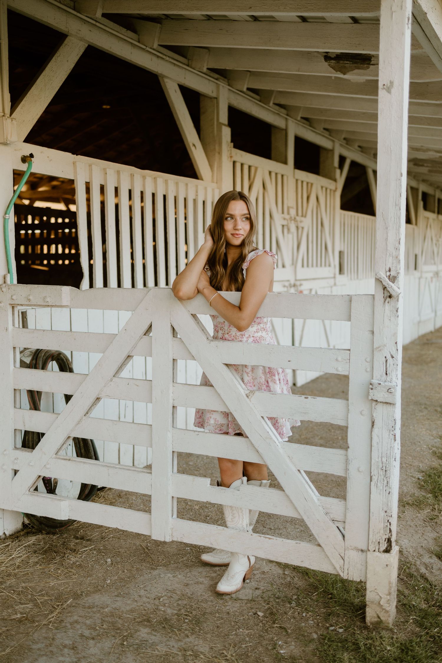A rustic white wooden barn interior with sunlight streaming through the slats.