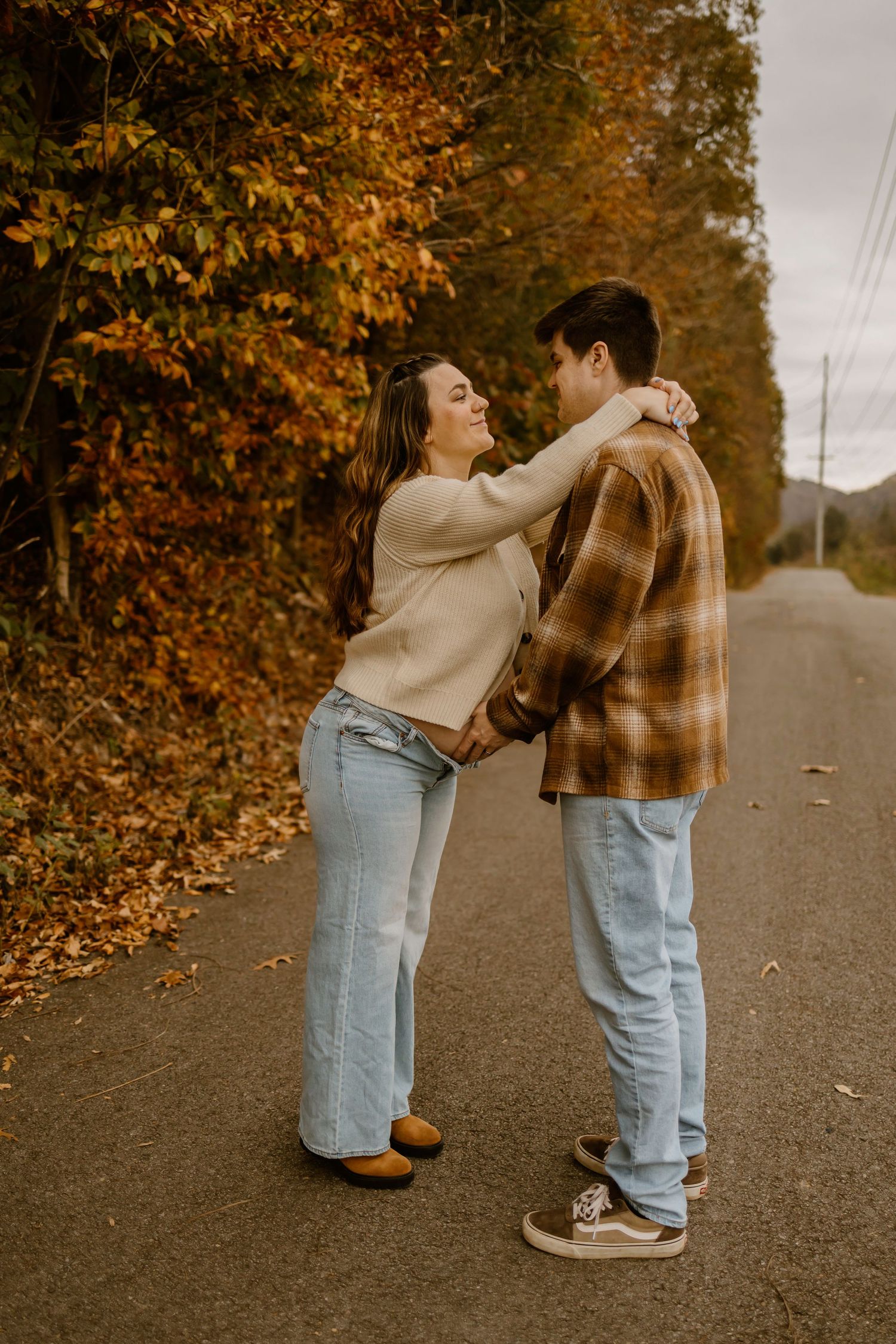 A playful sequence of two people interacting on an autumn path lined with orange leaves.