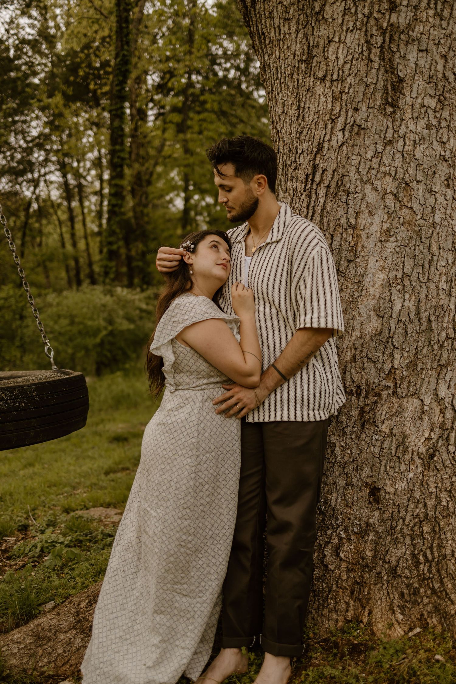 A romantic maternity photo session in a forest setting with soft natural lighting and vintage styling.