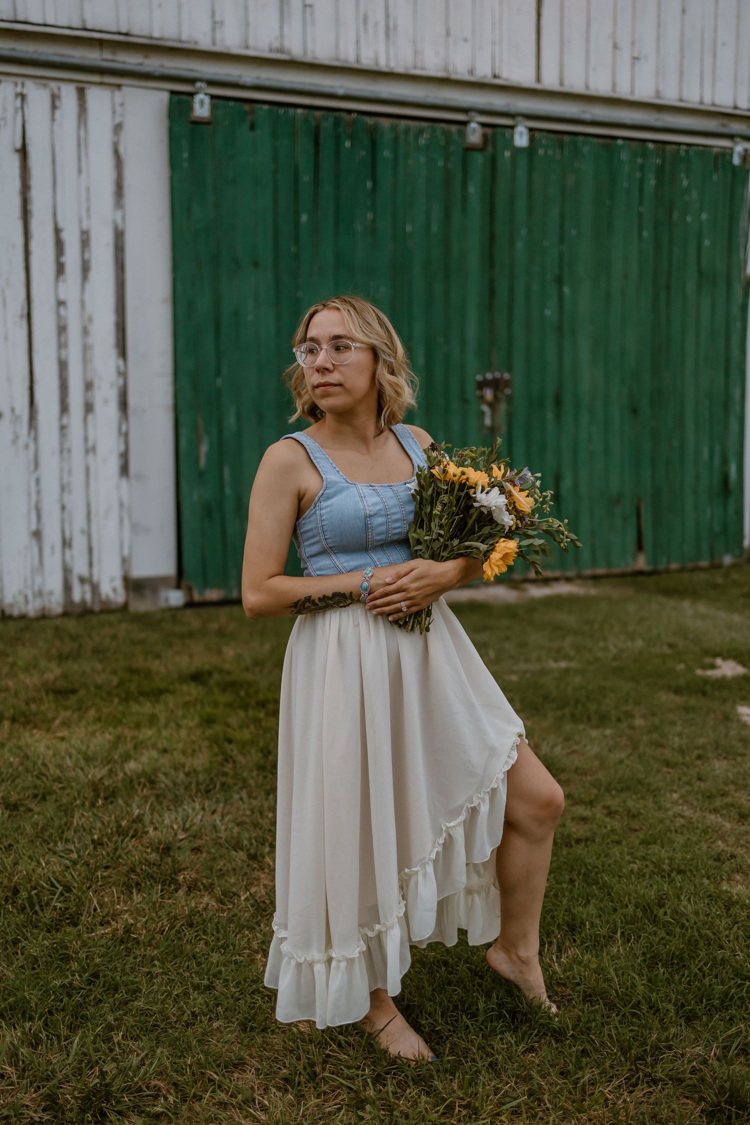 A summer portrait with wildflower bouquet against a rustic green barn door background.