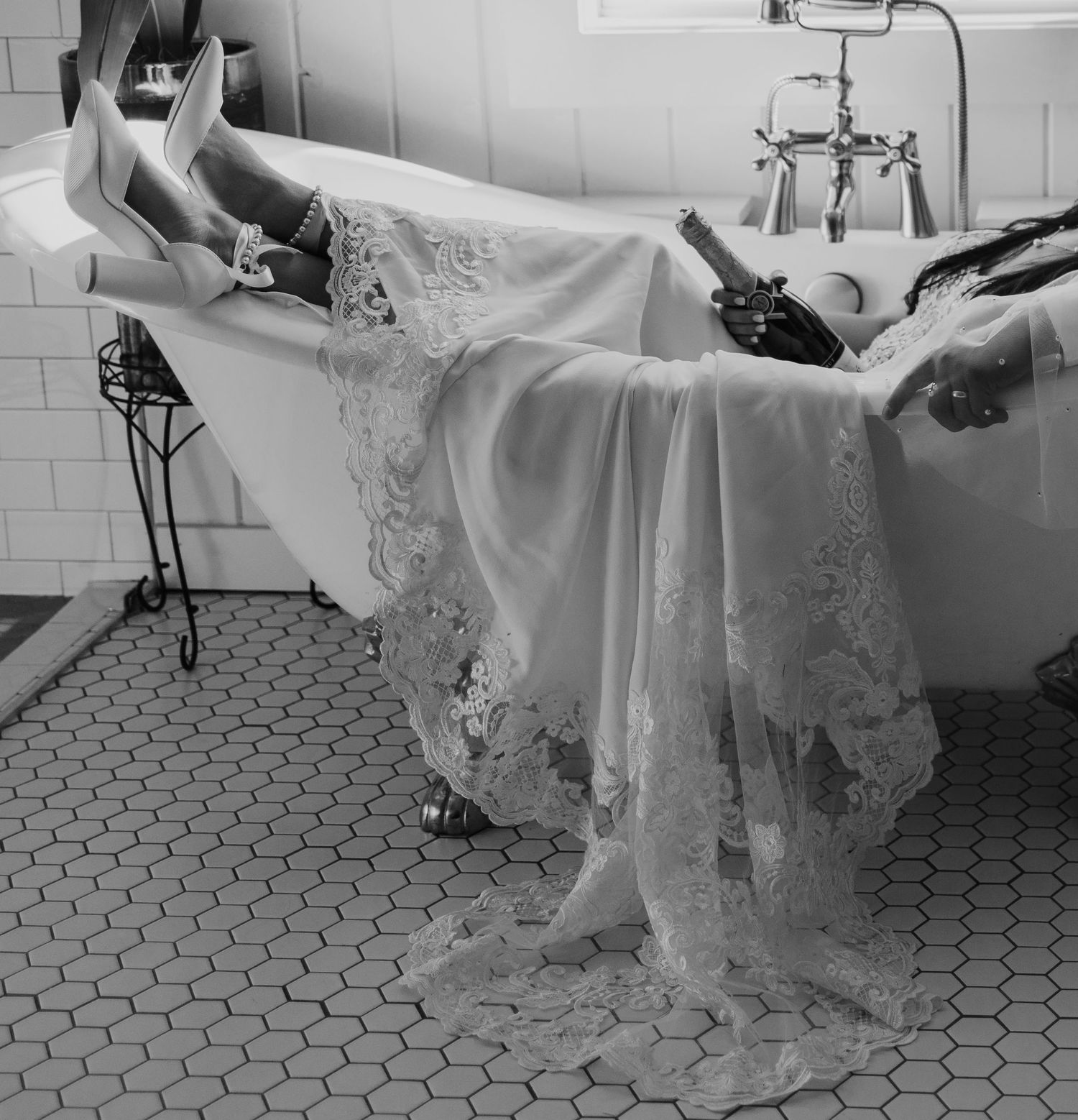 A wedding dress drapes elegantly over the side of a vintage clawfoot bathtub.