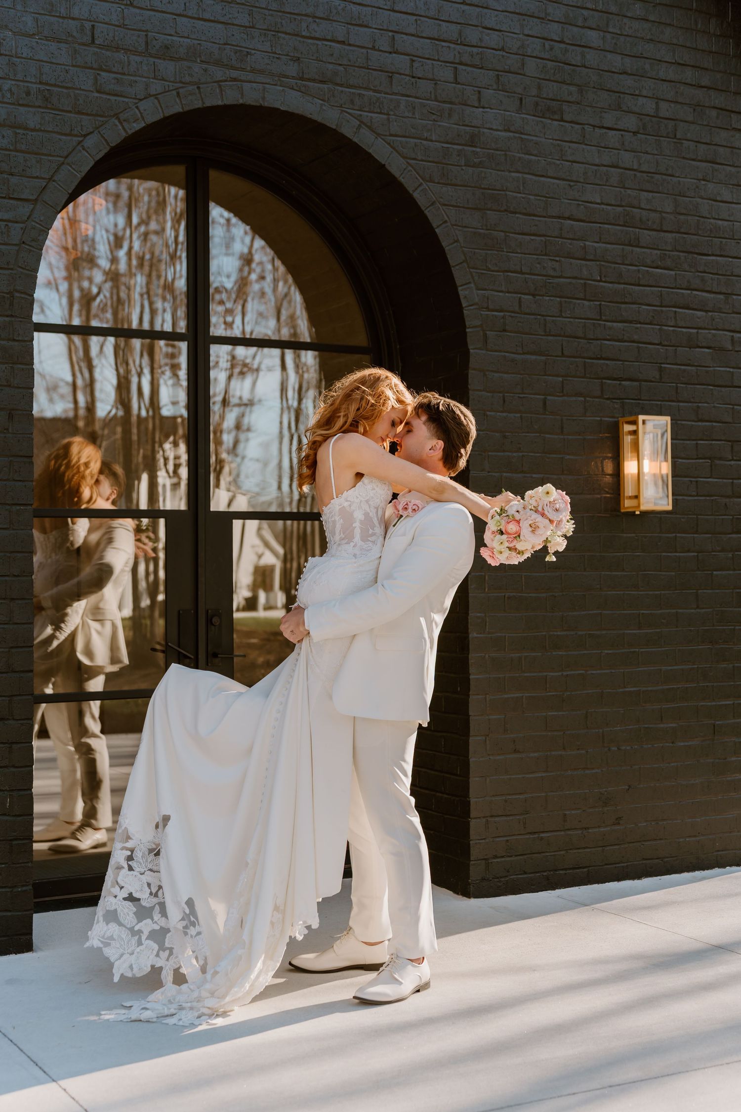 A romantic dance sequence against a dark brick wall with arched windows.