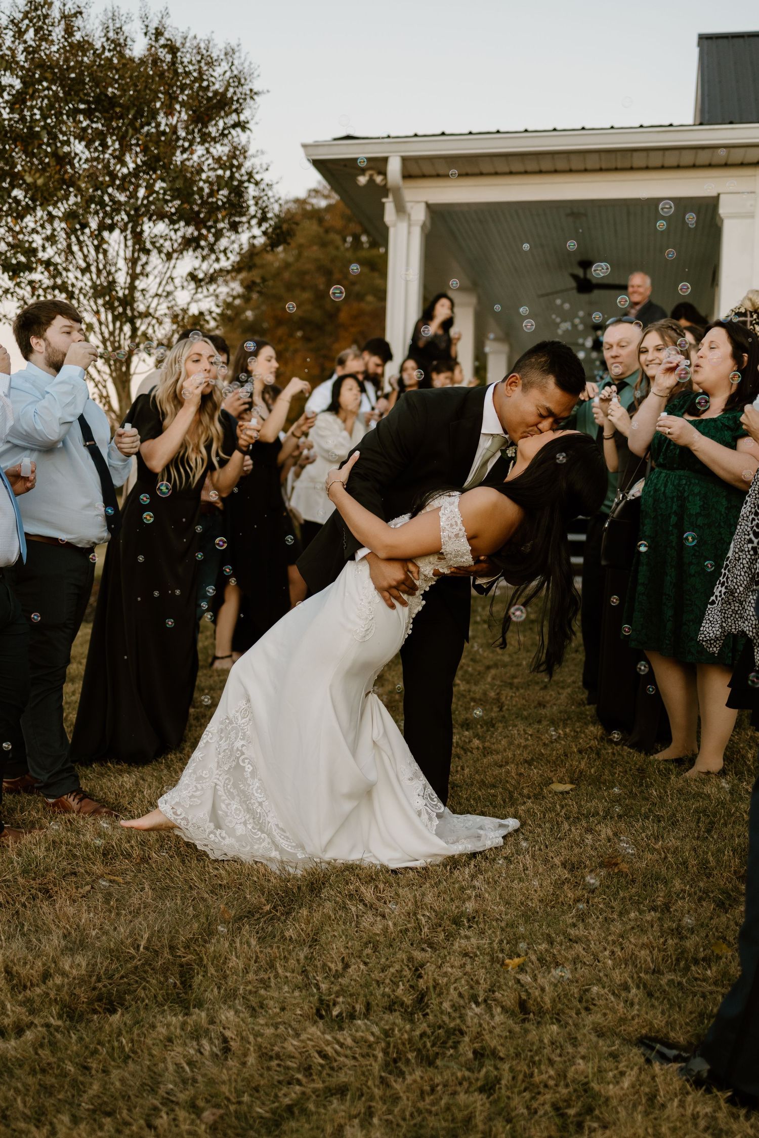 Wedding celebration with guests dancing outdoors at sunset.