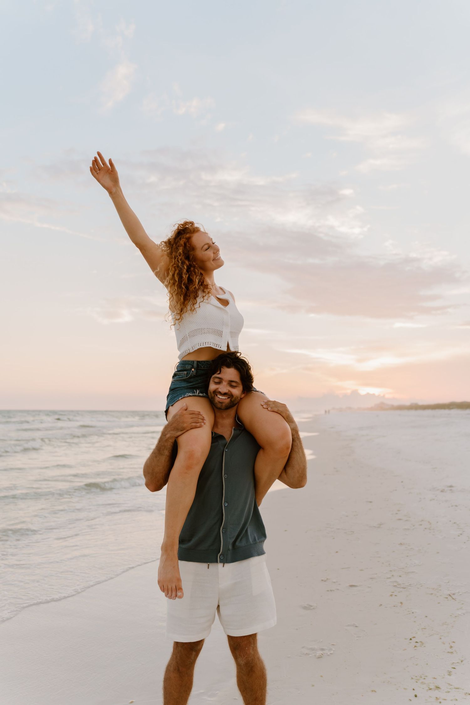 A joyful piggyback ride on a beach at sunset.
