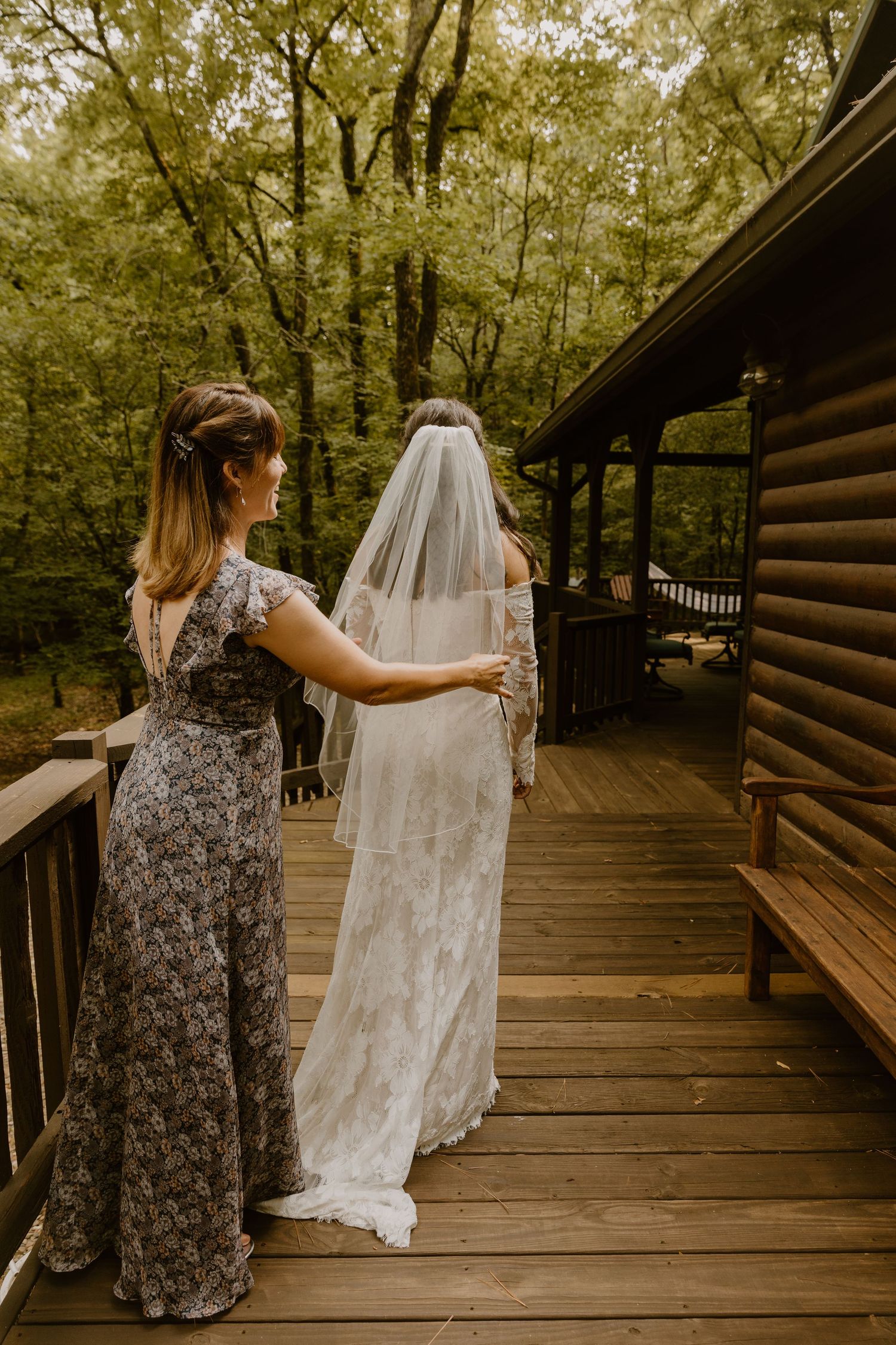 Wedding dress being displayed on wooden deck surrounded by trees.