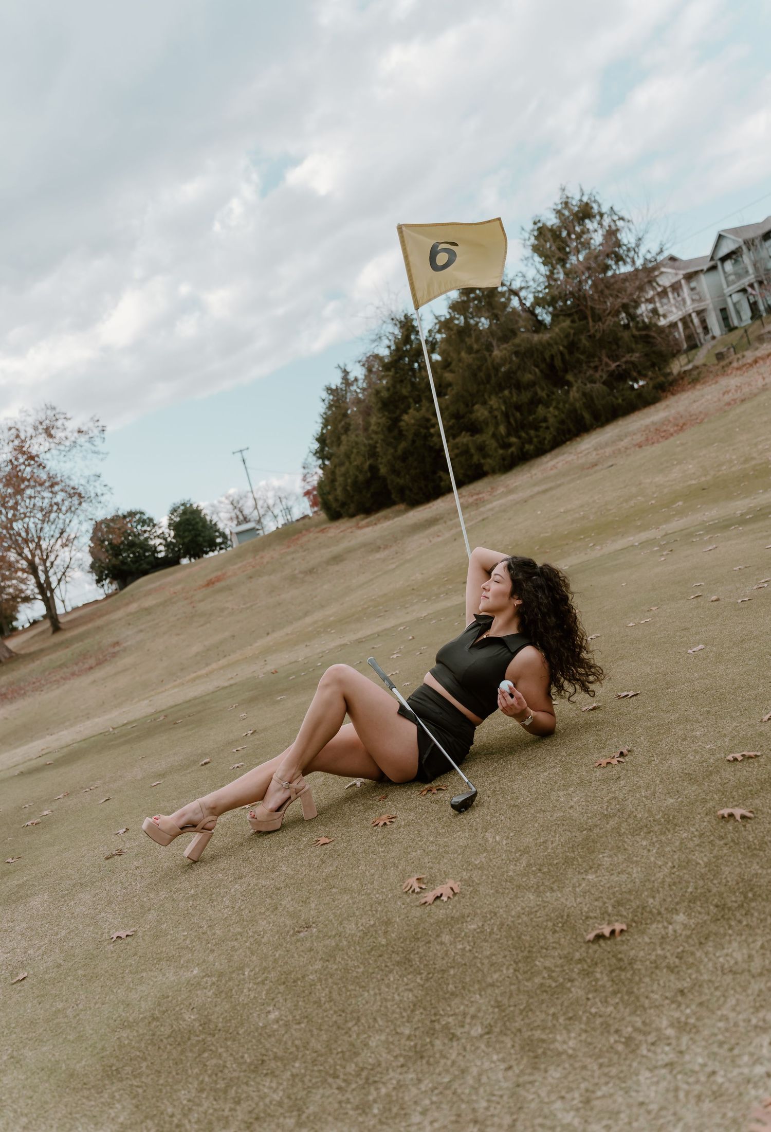 A series of photos showing someone lying on a grassy hill near a golf flag under cloudy skies.