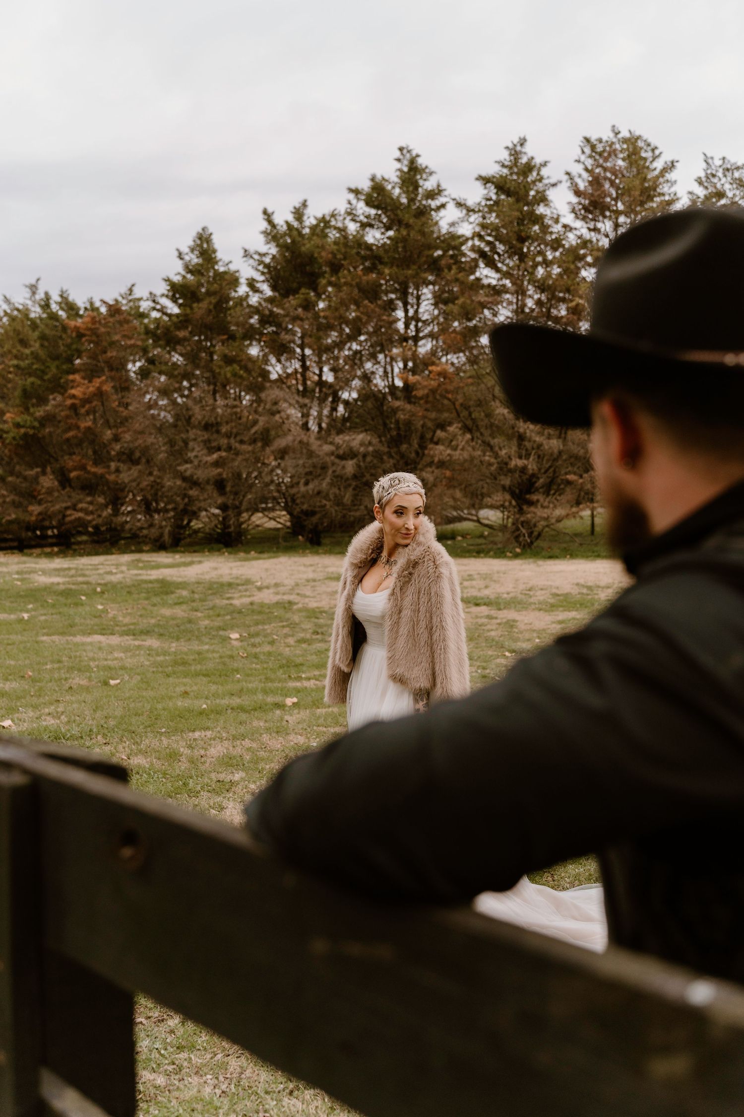 A wedding photography session in a rustic outdoor setting with pine trees in the background.
