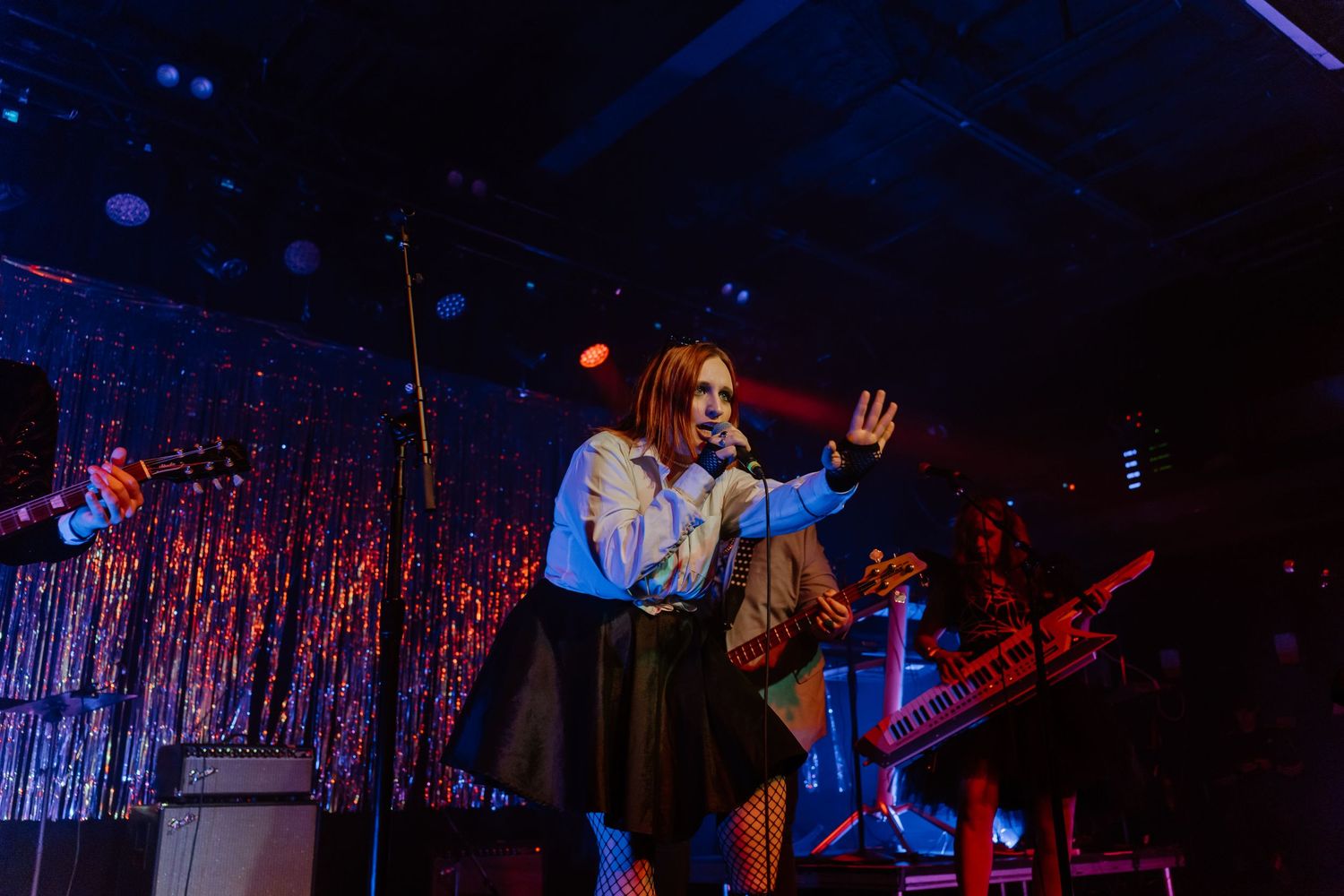 Stage performance with colorful lighting and silver tinsel backdrop creating a festive atmosphere.