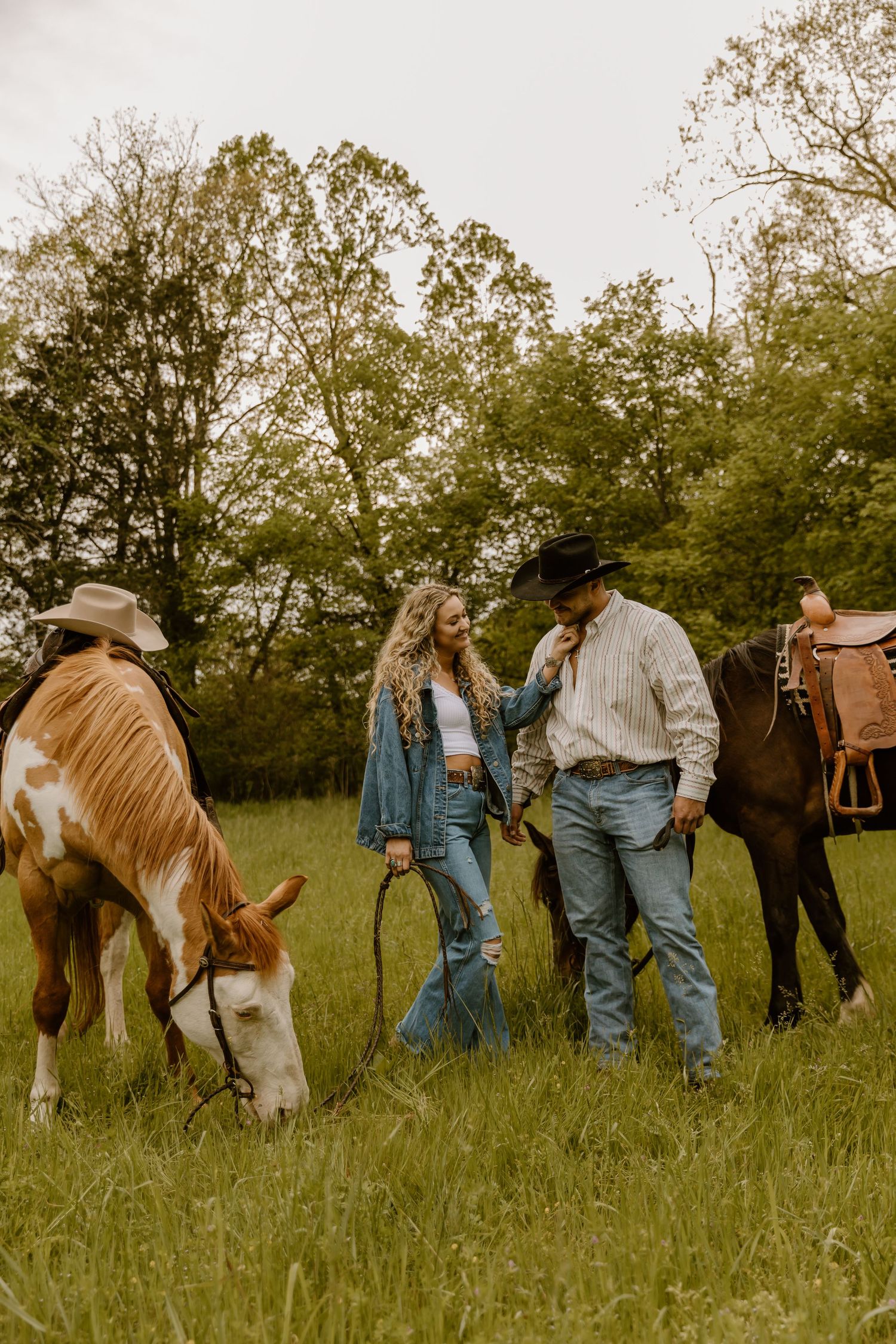 People and horses gather in a grassy field on a warm afternoon.
