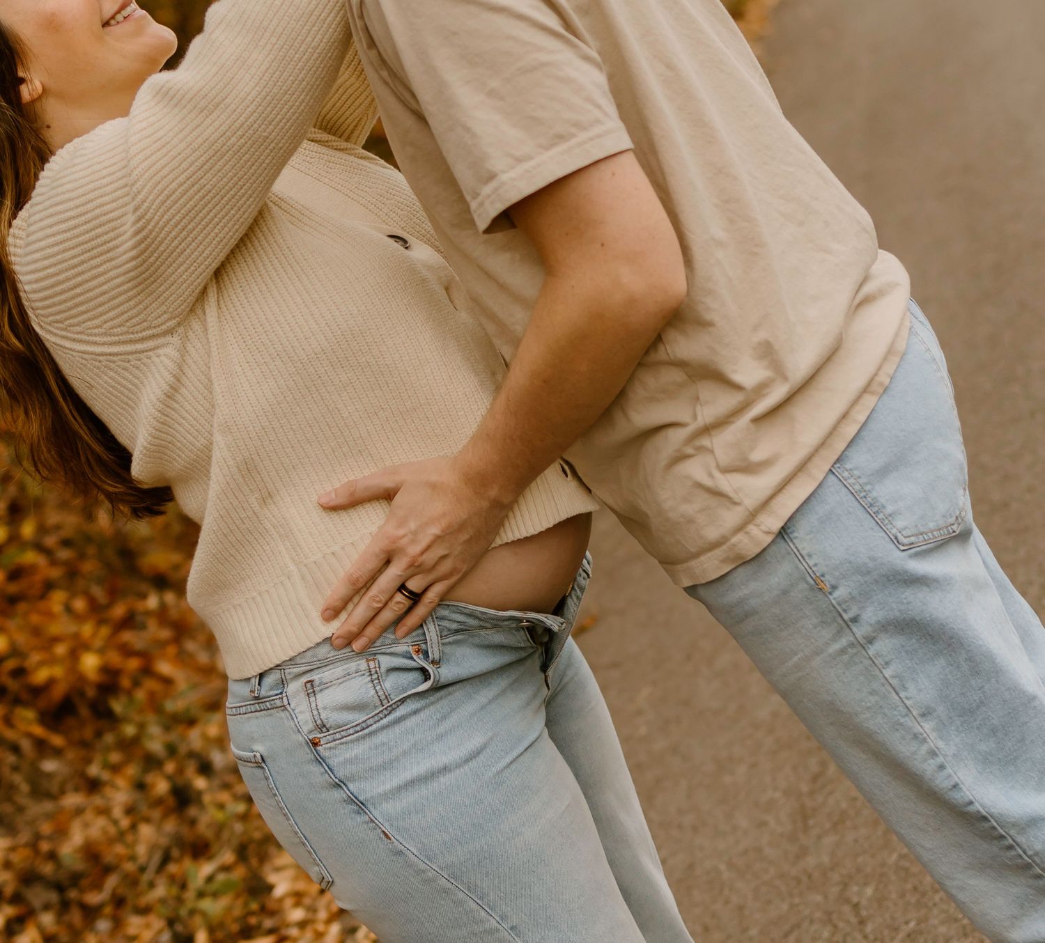A close-up shot of two people embracing in casual attire during autumn.